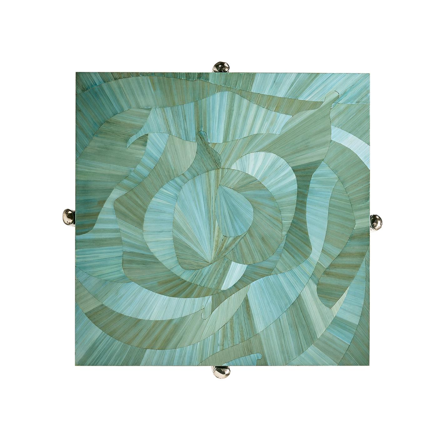 Le plateau carré présente une marqueterie de paille complexe appliquée à la main, rappelant les vagues de l'océan dans des tons bleus. Une finition laquée protectrice rehausse la beauté de l'incrustation de paille, garantissant un éclat et une