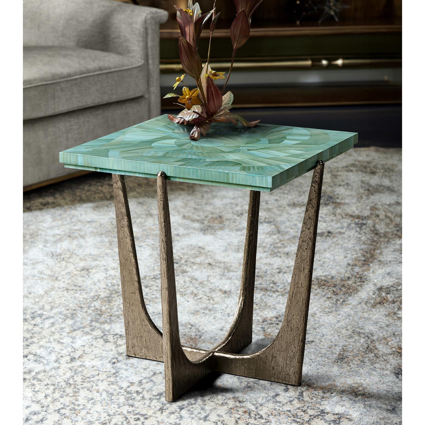 Le plateau carré présente une marqueterie de paille complexe appliquée à la main, rappelant les vagues de l'océan dans des tons bleus. Une finition laquée protectrice rehausse la beauté de l'incrustation de paille, garantissant un éclat et une