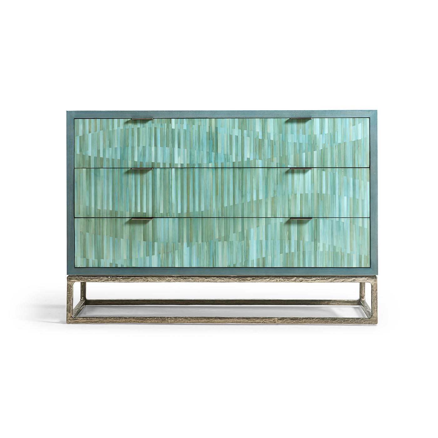 La cassa è rifinita con una ricca impiallacciatura di koto blu, per un look elegante e moderno che emana raffinatezza. I cassetti sono il vero pezzo forte, realizzati con paglia tinta tagliata in una disposizione meticolosa che crea un movimento