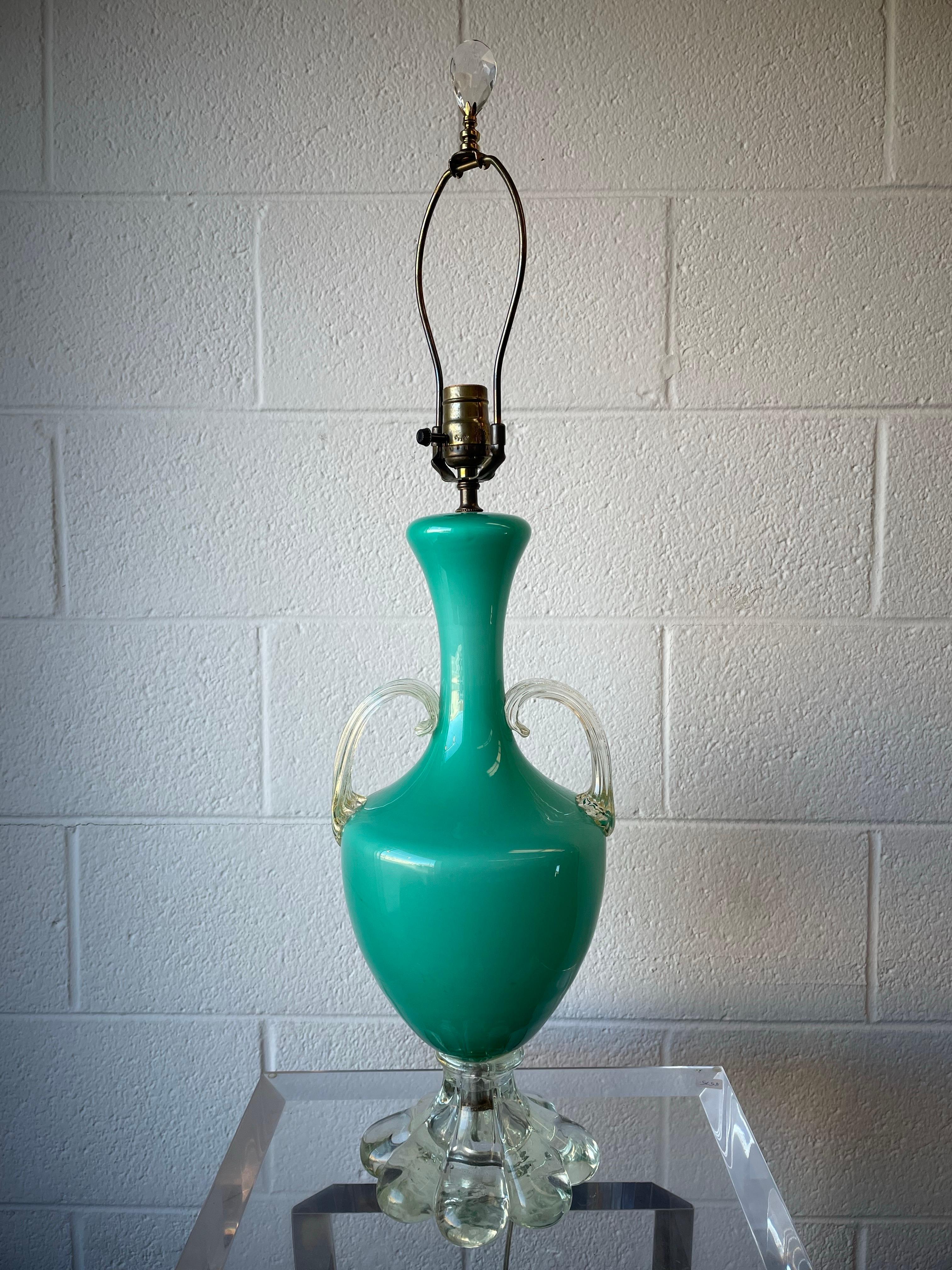 Fabulous mid twentieth century Murano glass lamp in a vibrant aqua color.
Lamp is an amphora design with a clear glass base and clear handles with gold flecks. Crystal finial included, shade is not for shipping purposes.
Original wiring in good