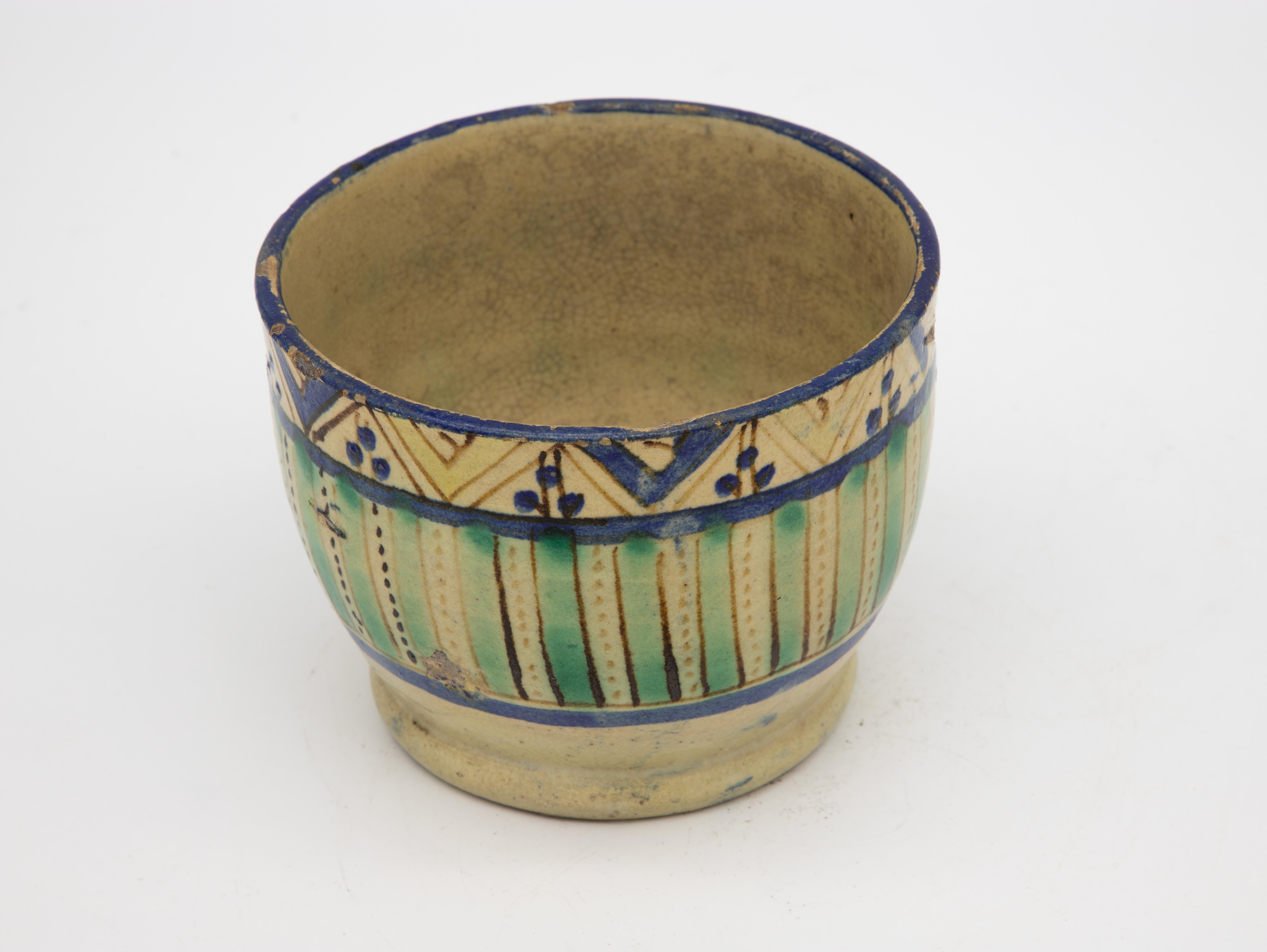 A beautiful handpainted Fes ceramic bowl or bowl brightly colored in aqua, blue, and saffron. Featuring a repeating pattern of stripes, lines, and dots. This Moroccan bowl was made in Fes at the end of 19th century. Wear consistent with age and use.