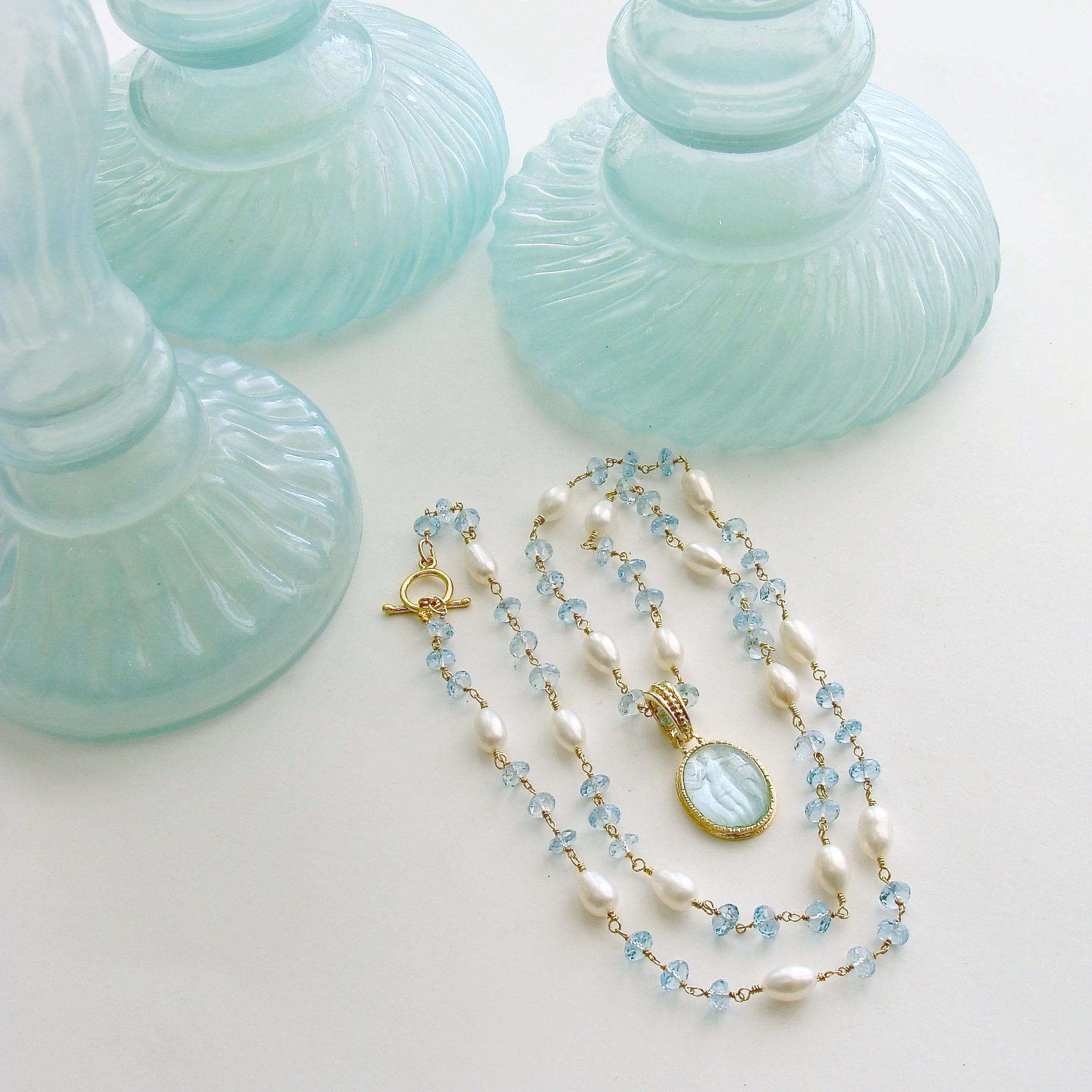 A long delicate necklace of hand-linked frothy blue topaz and creamy freshwater pearls, is perfectly coordinated with the powdery aqua color of a Venetian glass intaglio cameo pendant.  The subjects of the cameo intaglio are The Three Graces