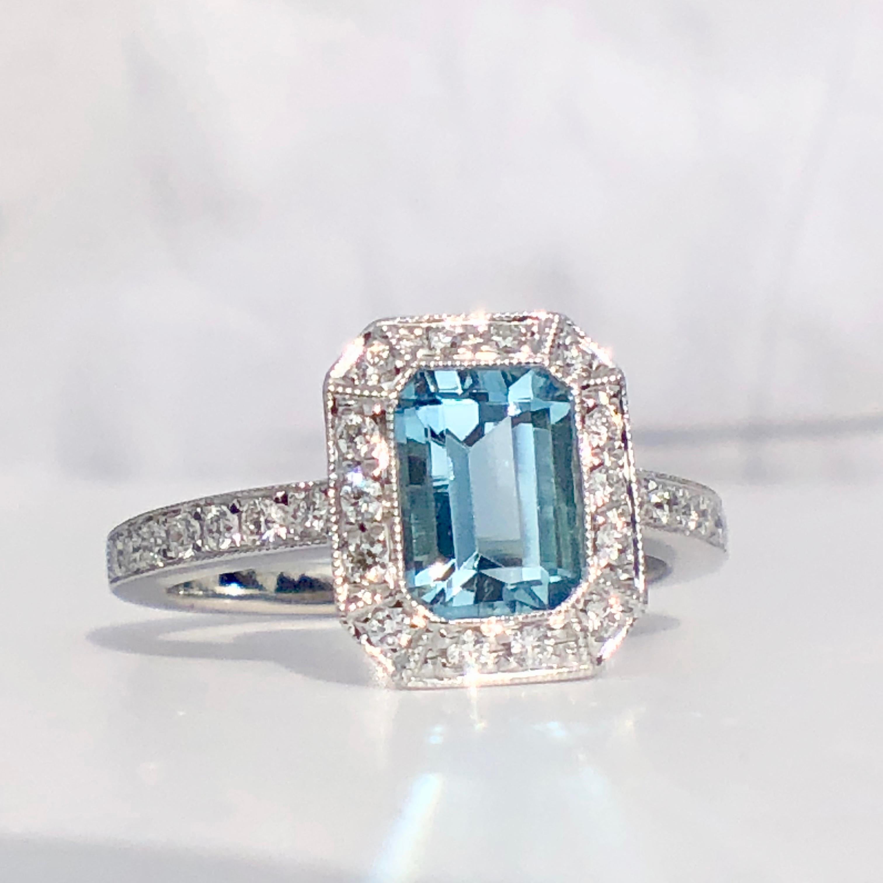 
A Step Cut  Aquamarine With A White Diamond Halo Surround and Diamond Shoulders

Set with a Deep Toned Aquamarine of 1.01ct and .27ct of Diamonds (Stamped to the band)

The birthstone for March Aquamarine 

Aquamarine evokes the purity of