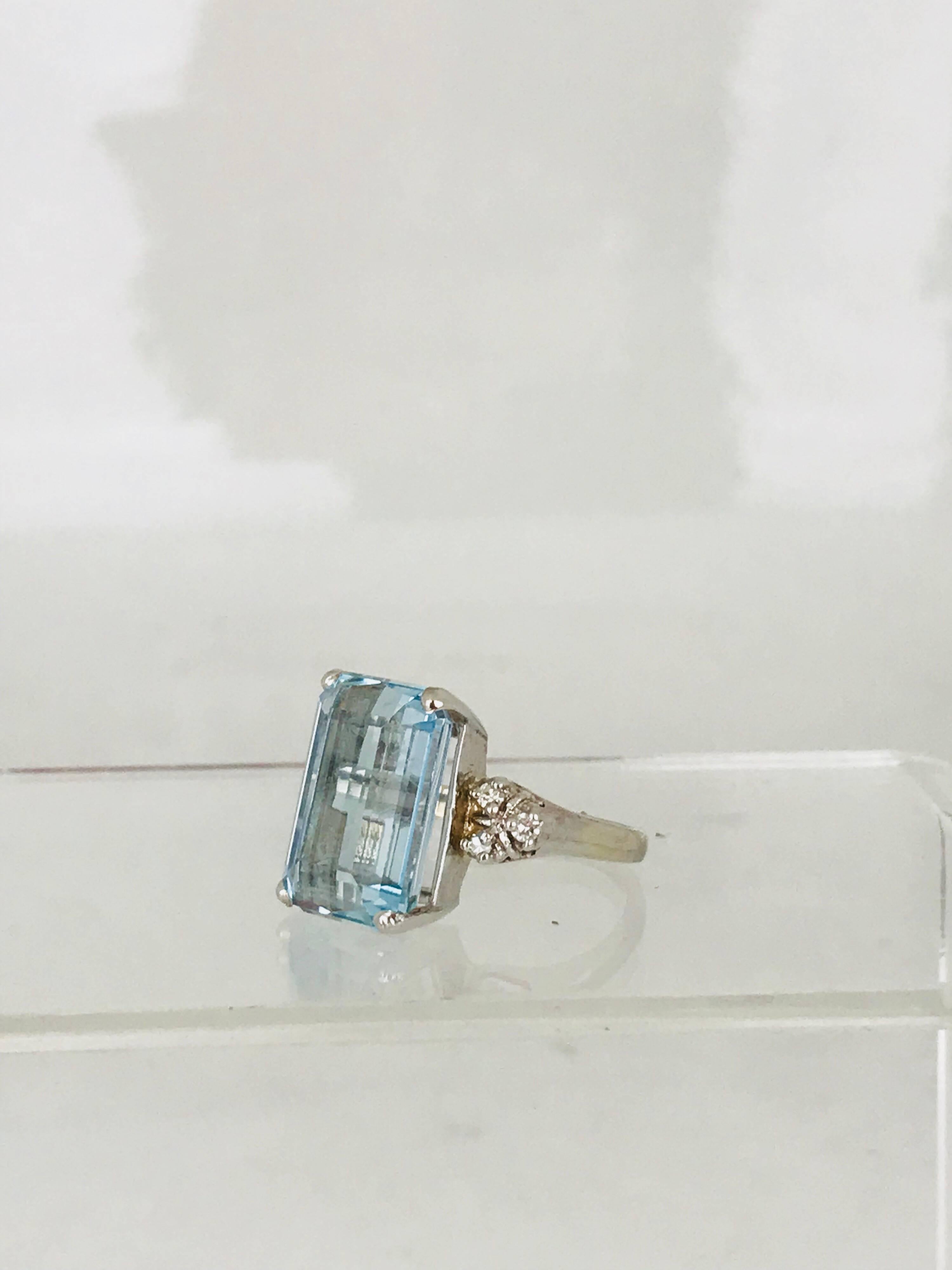 Emerald cut Aquamarine gemstone retro ring  design with accenting diamonds. 
 This ring is circa 1965. The Aquamarine measures 16.04-11.35 x 8.75 millimeters in diameter.  The weight is approximately 13.00 carats.
The ring is accented with (6)