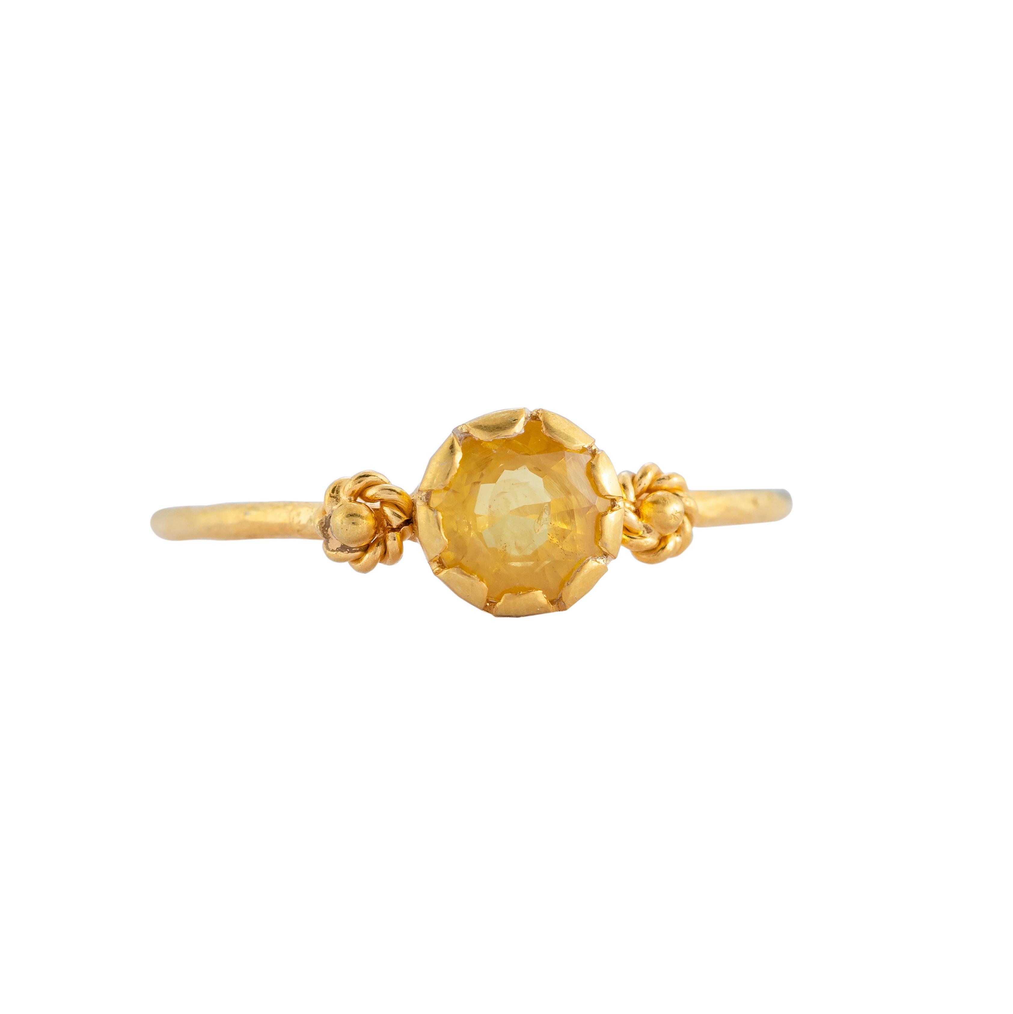 This lovely one-of-a-kind yellow sapphire 14k gold stacking ring, has been handmade in our workshops. It is embedded with a yellow sapphire which is flanked by embossed work. Wear it on it's own or stacked, whatever your preference.

Ring dimensions