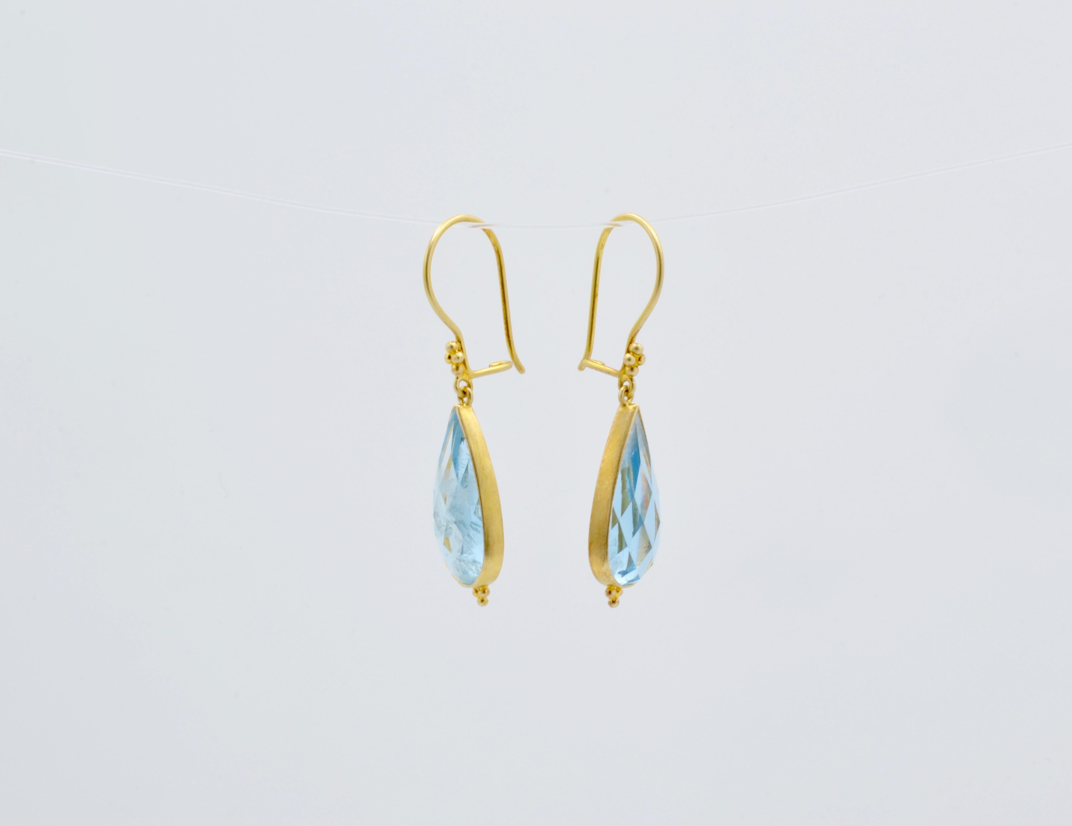 These lovely Steven Battelle designed teardrop earrings are beautifully cut aquamarine set in 18k gold. The setting is simple and elegant. The wire is delicately detailed for a romantic look. You can wear these beauties every day or for a special