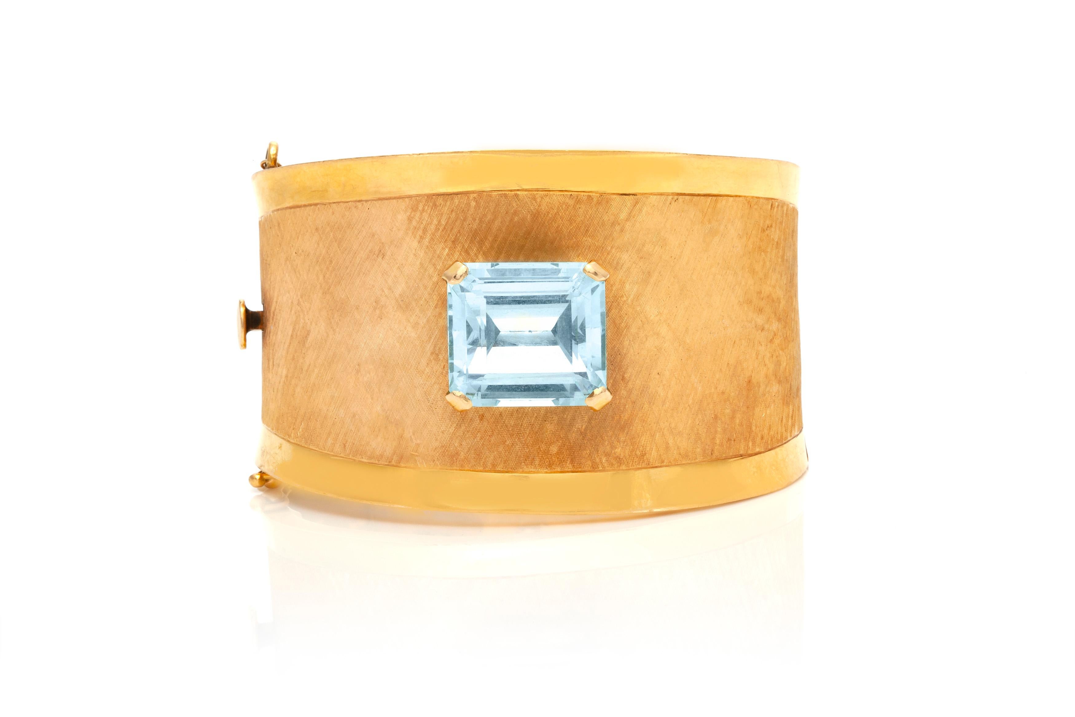 The cuff bracelet is finely crafted in 18k yellow gold with aquamarine center stone weighing approximately total of 20.00 carat.
