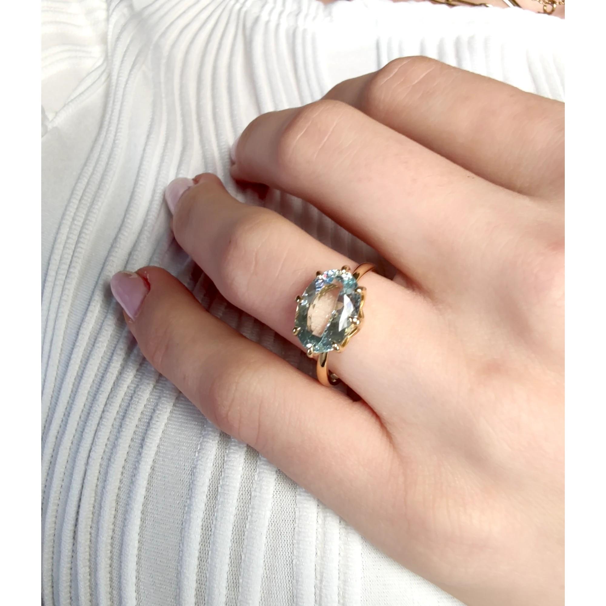 This gemstone engagement ring showcases a 3,38 -carat oval-cut aquamarine, elegantly set in prongs and complemented by round brilliant cut diamonds adorning the shoulders.  The ring is meticulously handcrafted in 18k yellow gold, creating a stunning
