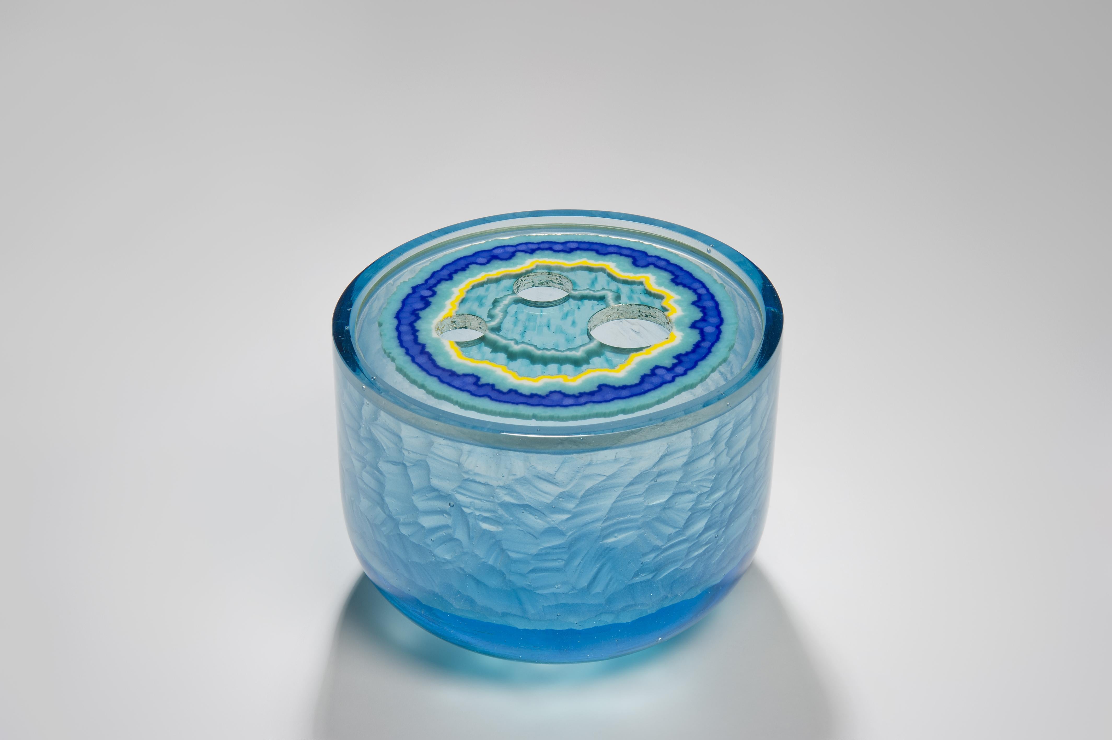 Aquamarine Agate Geode is a unique aqua, turquoise, blue and yellow sculptural piece created from cast glass by the British artist Angela Jarman. Using the lost wax technique, the base is cast pale blue lead crystal. The top disc insert is created