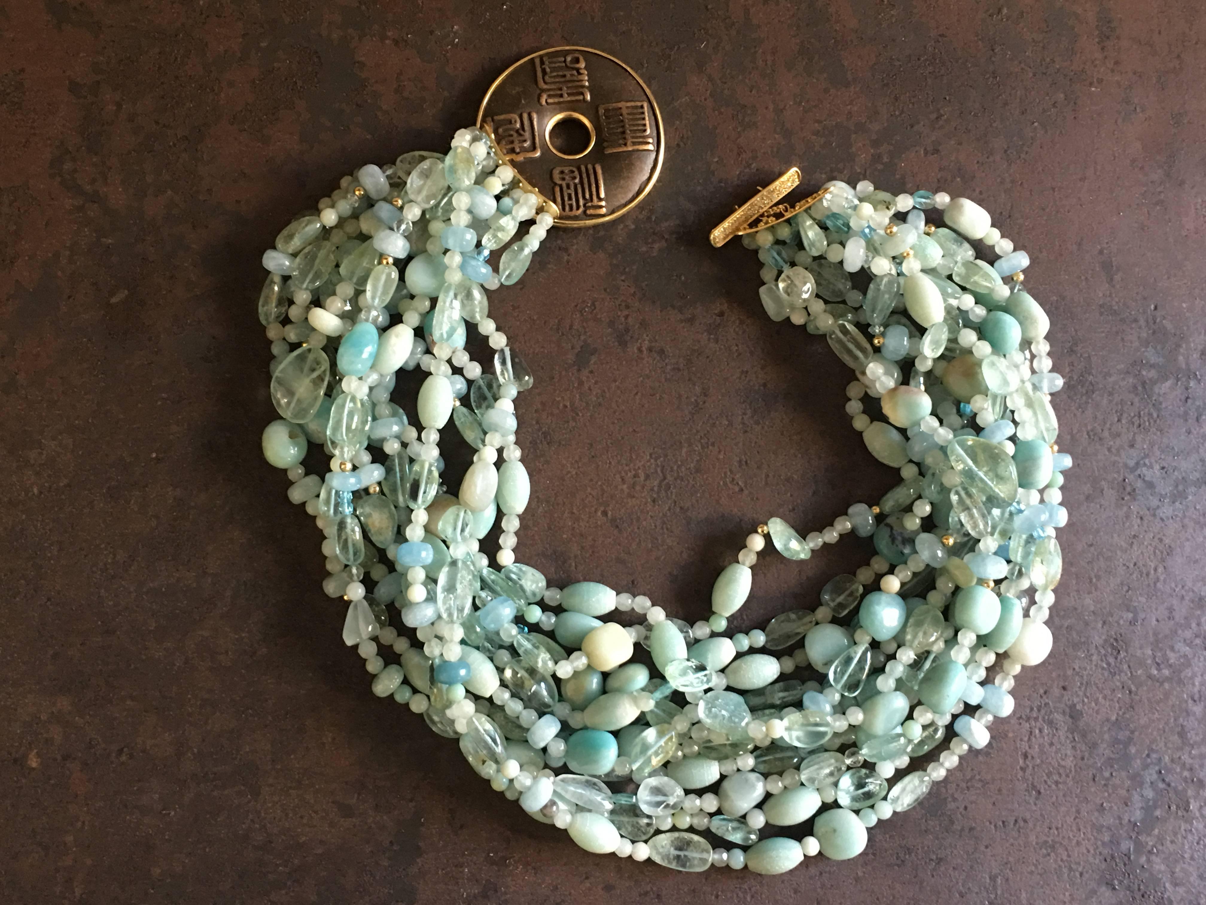 Multi string necklace with different shape and color of aquamarine stone, amazonite, gold beads.  The closing necklace was an antiques Japanese coins in bronze, refined with gold and diamonds. Length 45 cm.
All jewelry is new and has never been