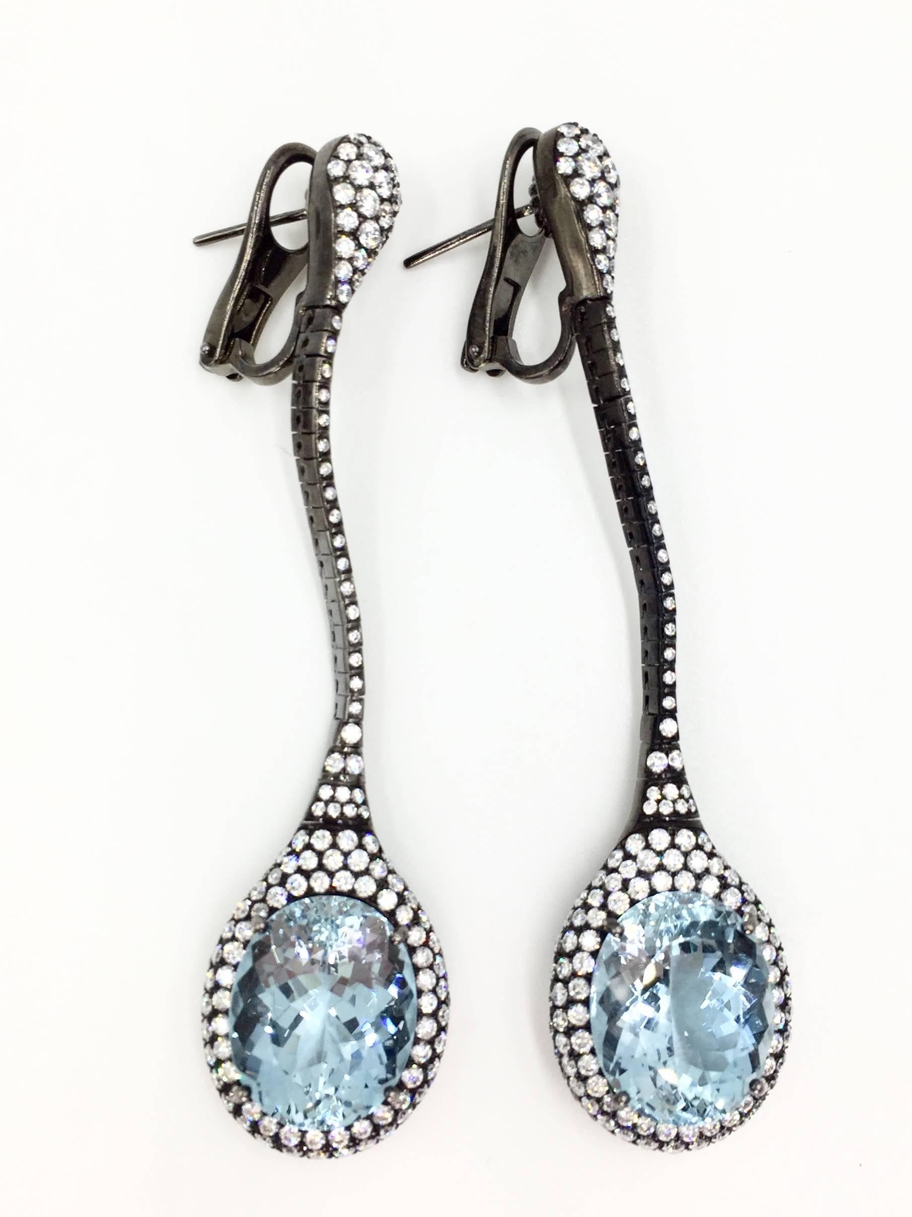 Modern and eye catching drop earrings by J. Stella. High quality white diamonds pop against the polished black 18K gold. Two large beautiful genuine oval faceted aquamarines have a total weight of 19.26 carats. 304 white round brilliant diamonds