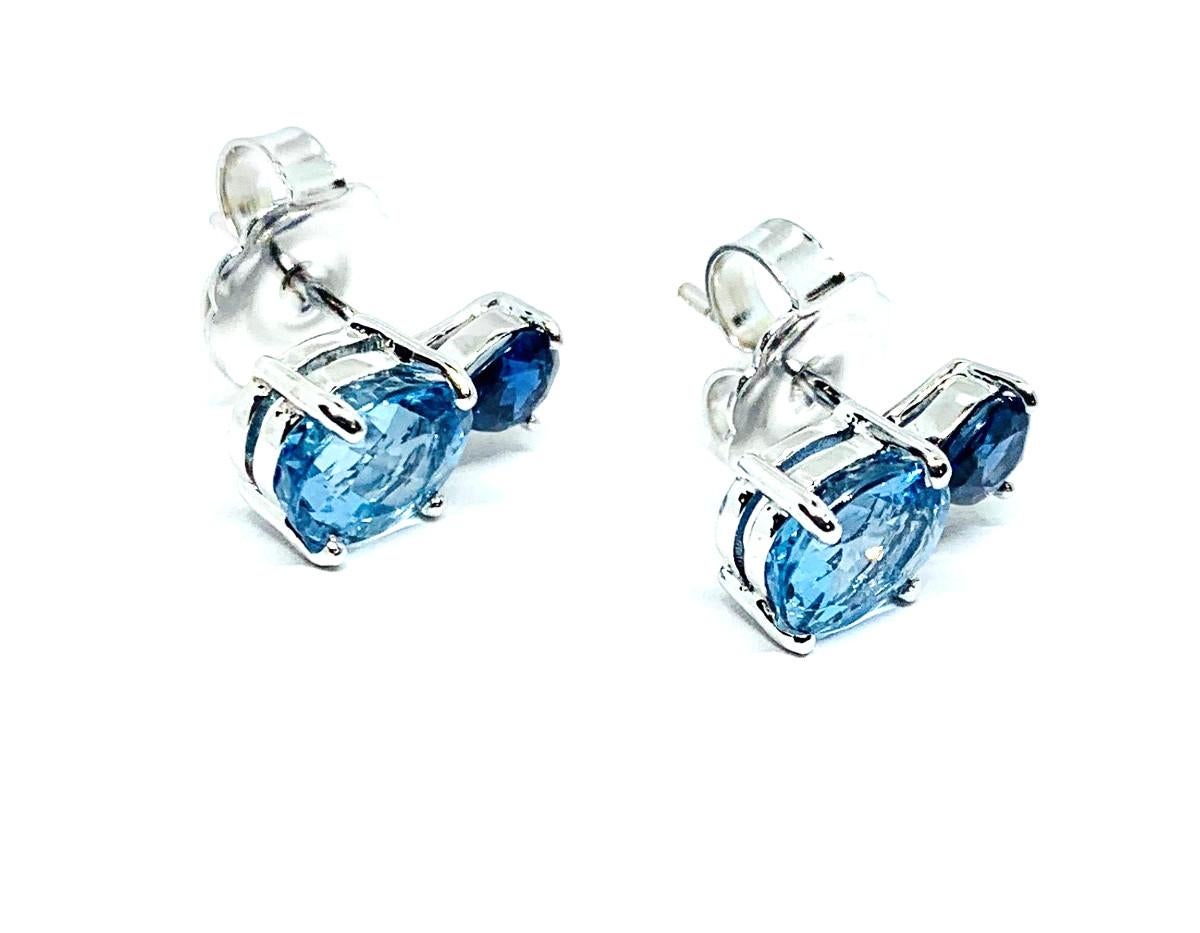 These stunning drop earrings feature vibrant aquamarine ovals and rich sapphire ovals set with 18k white gold posts. The combination of brilliant blue aquamarines and deep, rich blue sapphires makes these particularly eye catching. A precious 