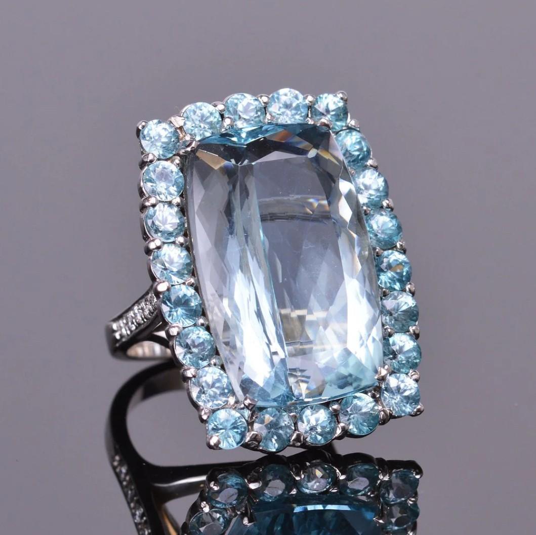 Una meravigliosa acquamarina da 25,86 carati circondata da un'aureola di 8,80 carati di splendidi zirconi blu. Con .30 carati di diamanti bianchi che accentuano queste bellissime pietre. Il tutto incastonato con gusto in oro bianco 18 carati. Le