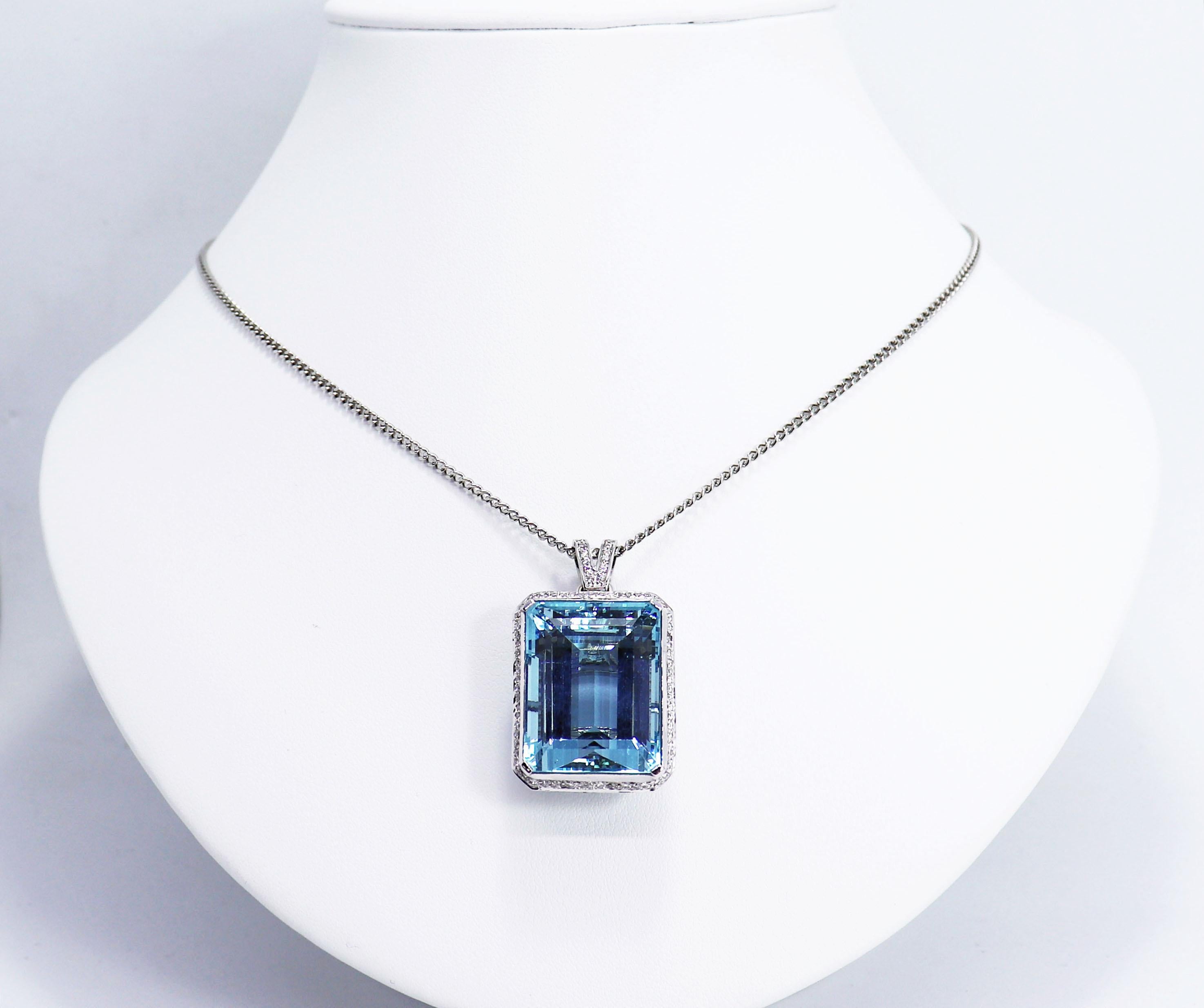 Exquisite pendant set with a high quality intense blue emerald cut aquamarine weighing approximately 39.00 carats. The beautiful stone has been set in a four claw open work fancy basket mount set with approximately 1.12 carats of brilliant cut