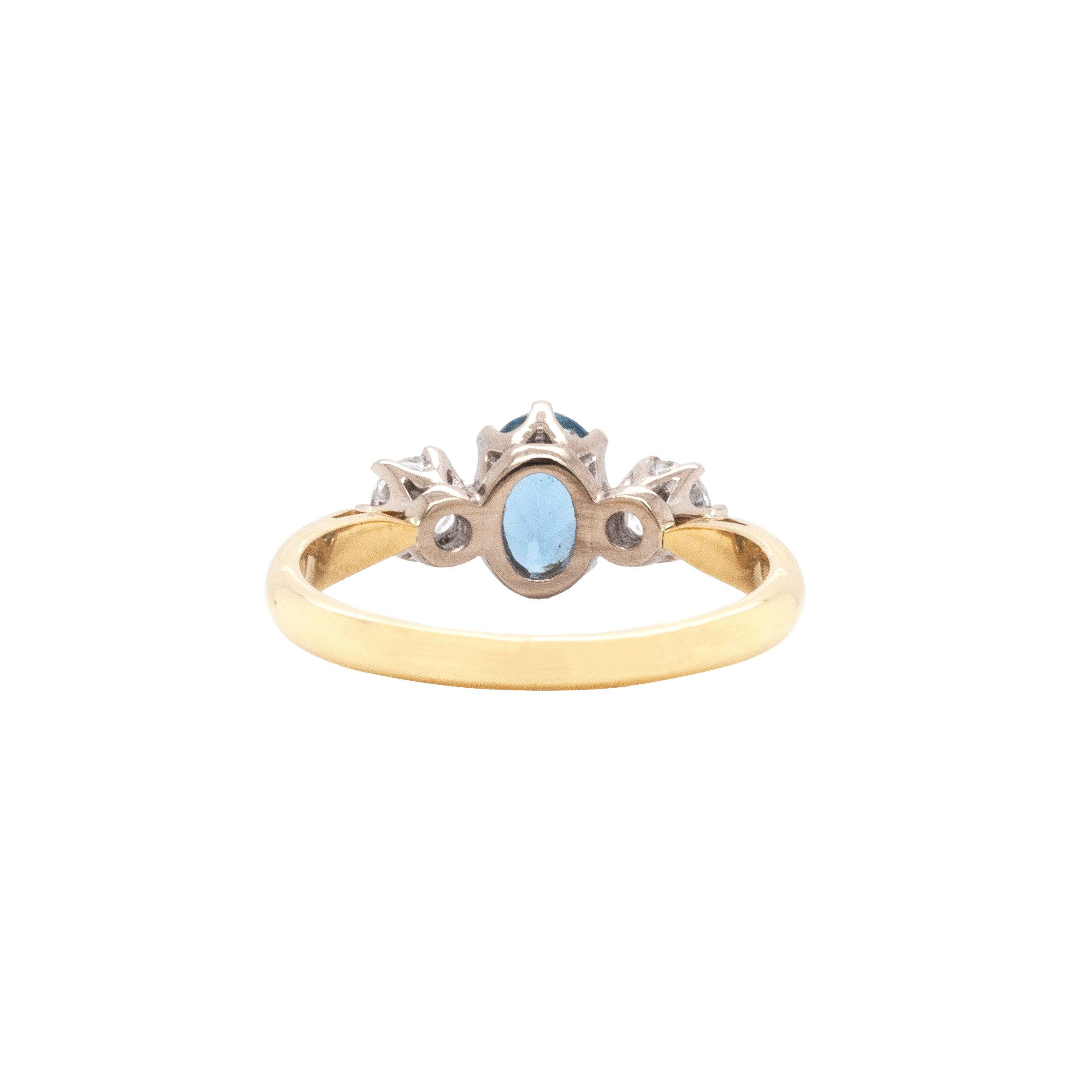 Cette exquise bague de fiançailles à trois pierres présente une charmante combinaison d'aigue-marine et de diamants, le tout serti dans un design intemporel. 

Au centre de cette merveilleuse bague se trouve une vibrante aigue-marine ovale, pesant