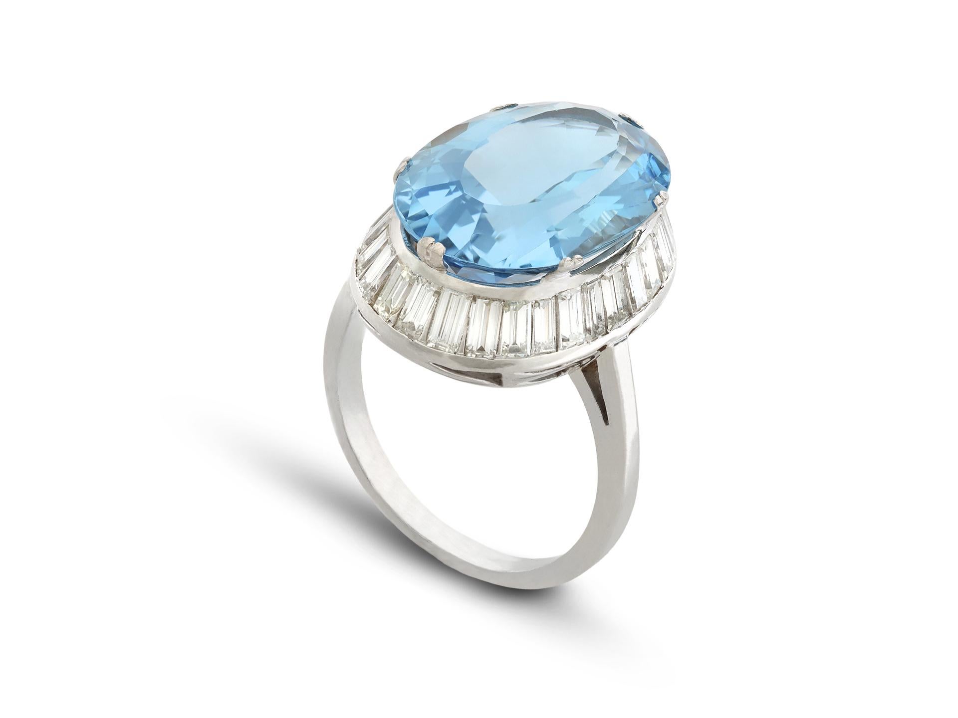Anello a grappolo con acquamarina e diamanti. Al centro è incastonata un'acquamarina naturale di taglio ovale in una montatura a griffe aperta sul retro con un peso approssimativo di 9,00 carati, circondata da ventotto diamanti rettangolari taglio