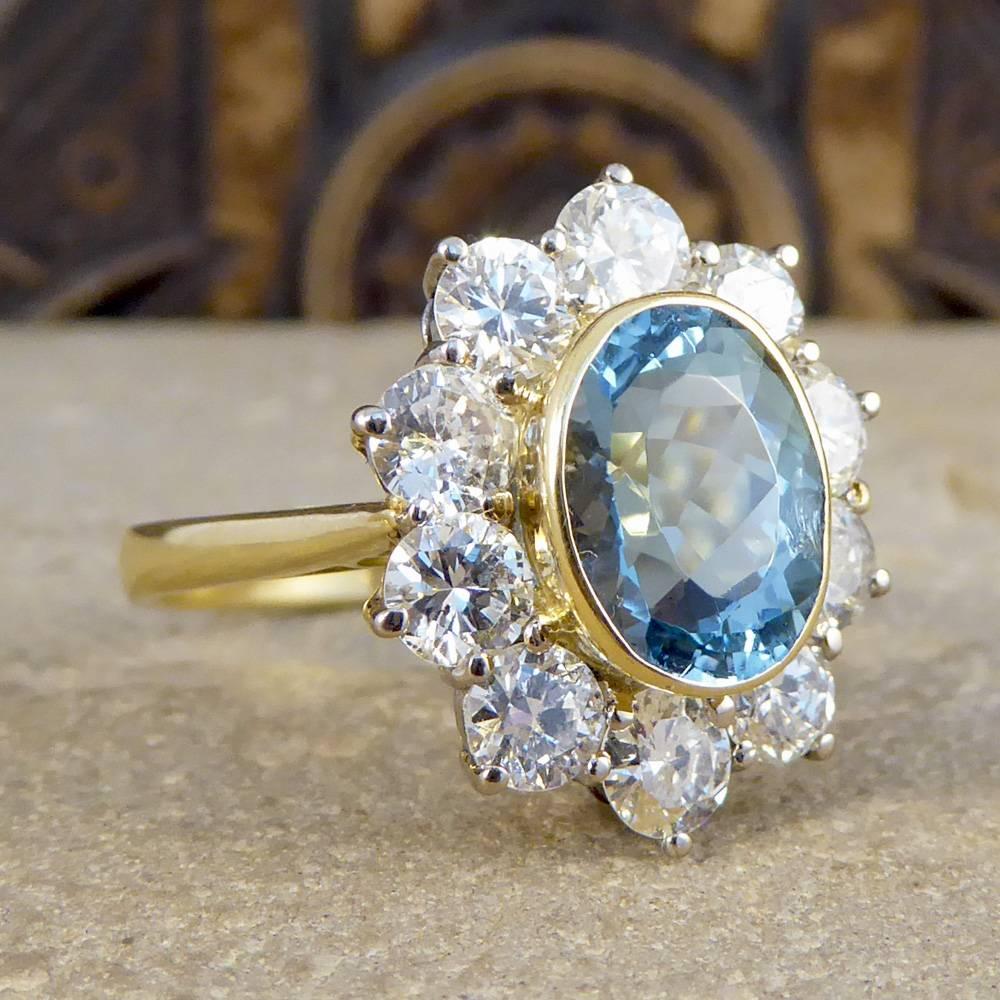 This beautiful Contemporary Aquamarine and Diamond ring would make the perfect engagement or statement ring. With one single 2.35ct Oval Cut Aquamarine in a 18ct yellow Gold rub over collar setting surrounded by 10 Round Brilliant Cut Diamonds