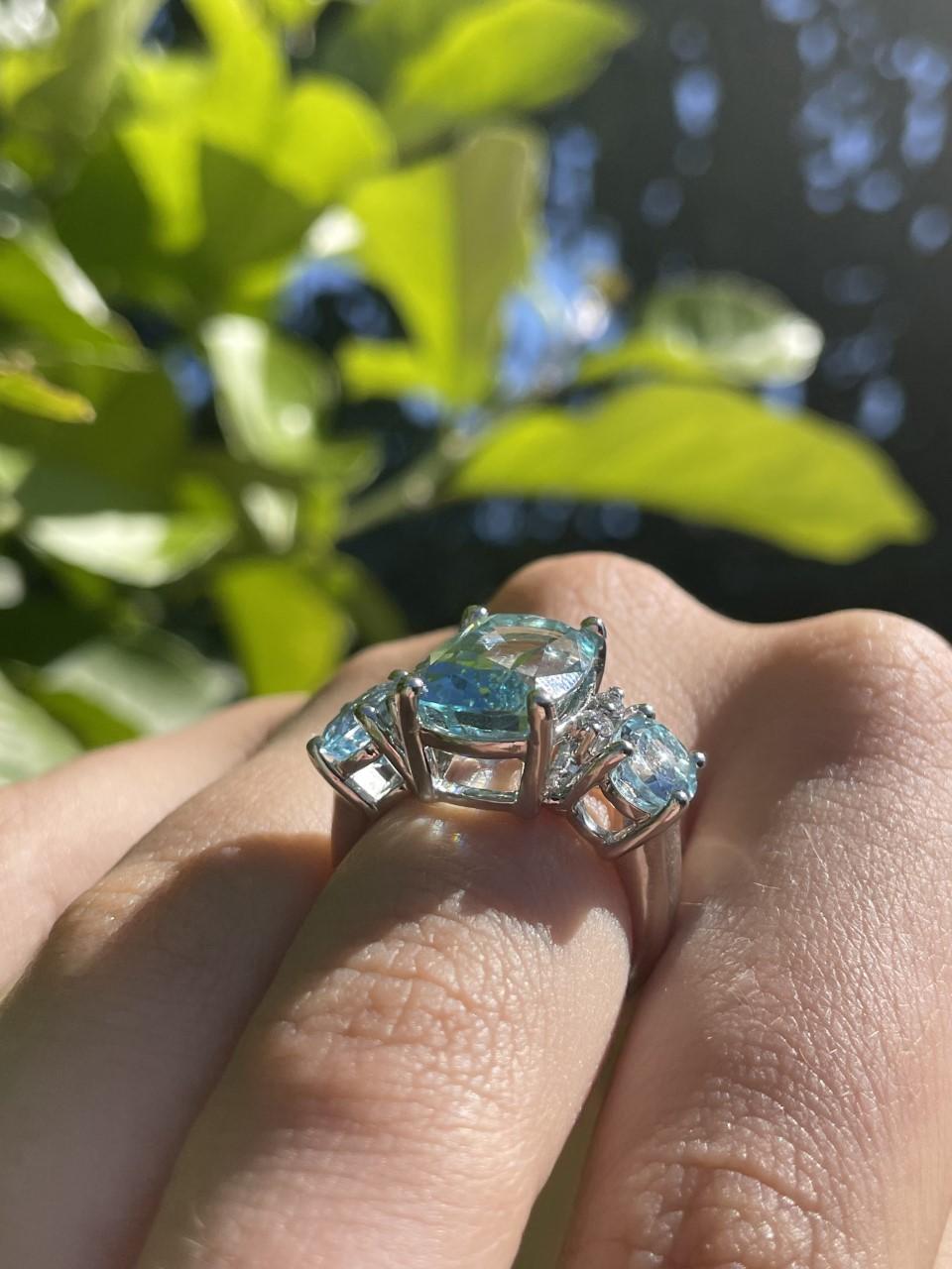 Aquamarine and Diamond Cocktail/Dress Ring with 3 oval aquamarines and 4 round brilliant cut diamonds. The stones are set in an elegant 18ct white gold four claw setting. The shank measures 4.2mm at the shoulder, tapering down to 2.8mm and has a