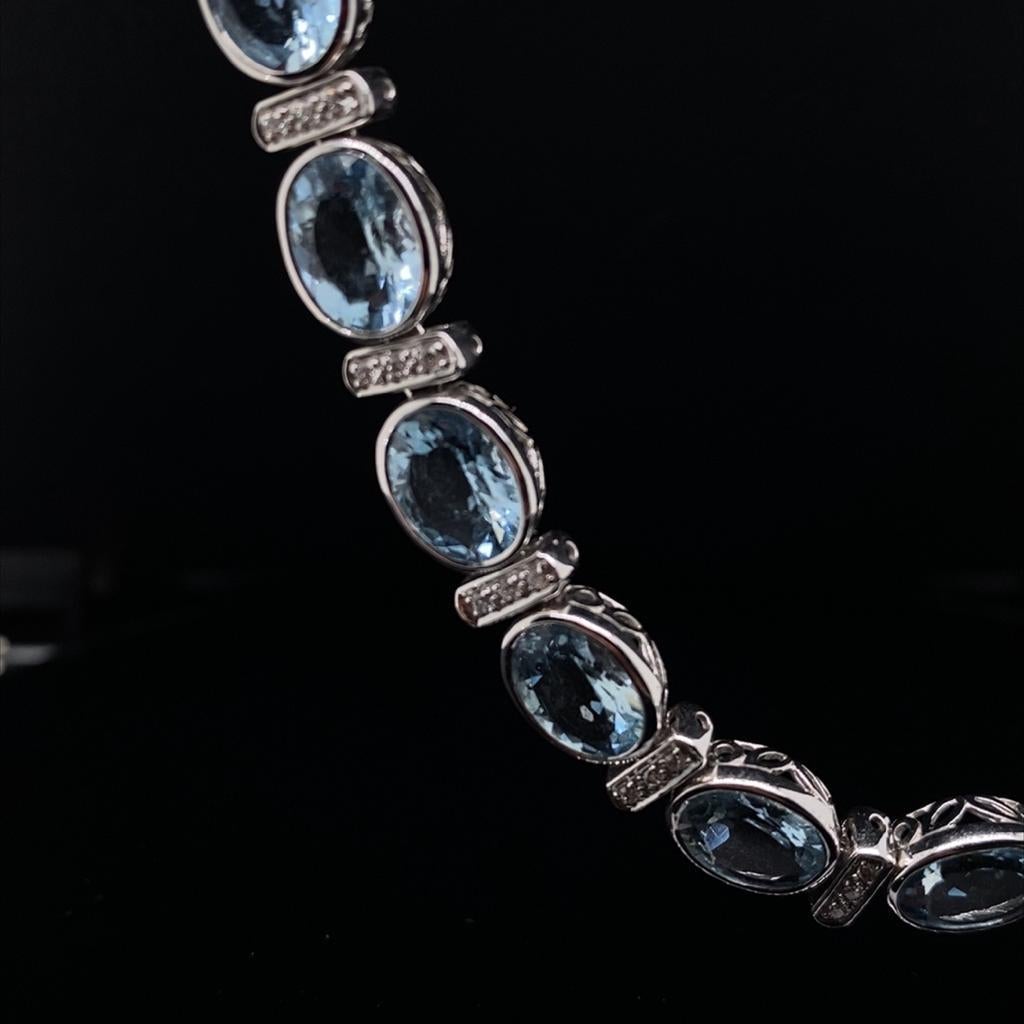An aquamarine and diamond collar necklace in 18 karat white gold.

This impressive collar necklace comprises of elegant faceted oval aquamarines alternated with an 18 karat white gold diamond set bar between each stone.

The aquamarines are a bright