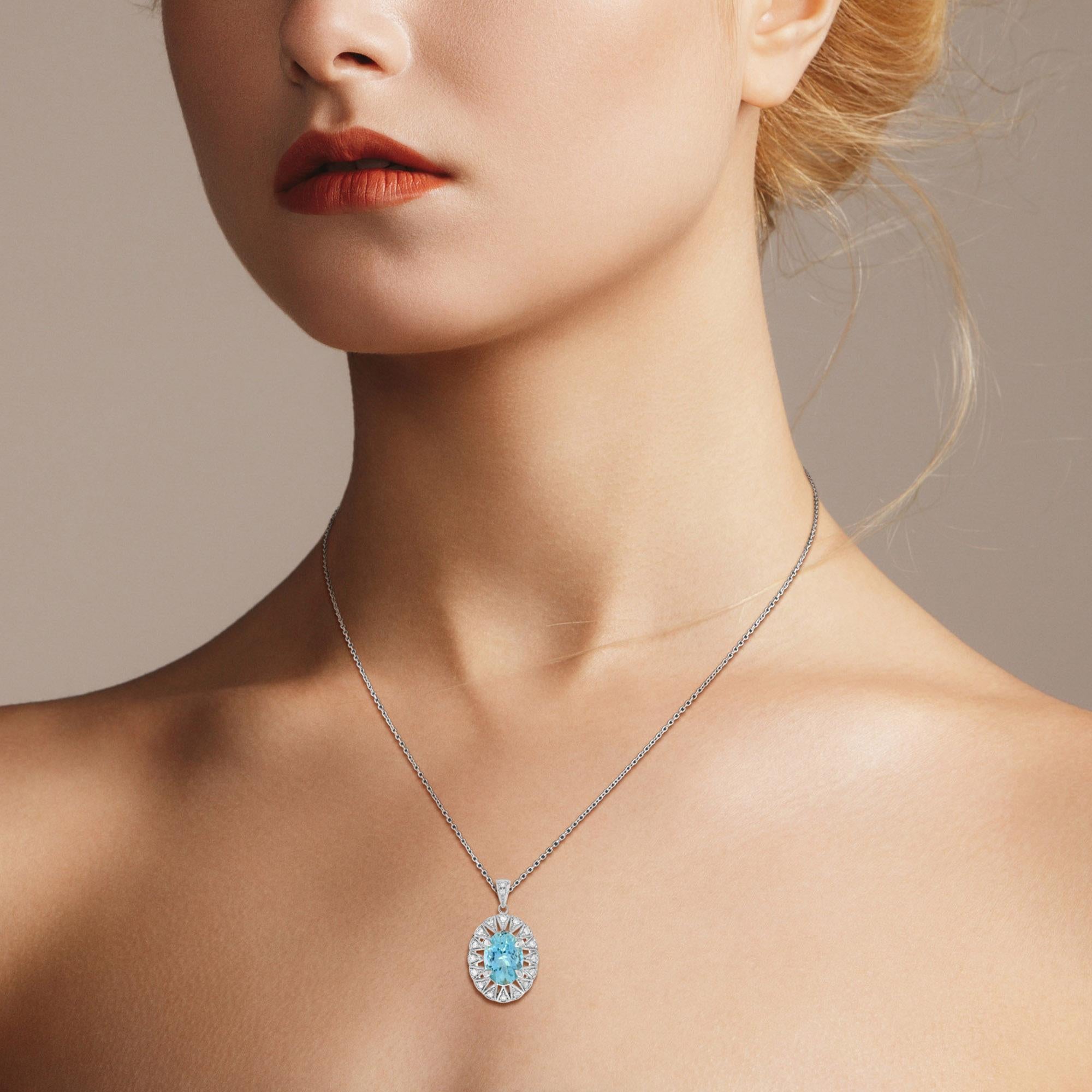 This gorgeous openwork pendant is centered with a 1.5 carat oval aquamarine. The center is accented with fourteen bead set round brilliant cut diamonds with milgrain detailing and a lacy openwork setting. A beautiful, rare, and delicate pendant.
