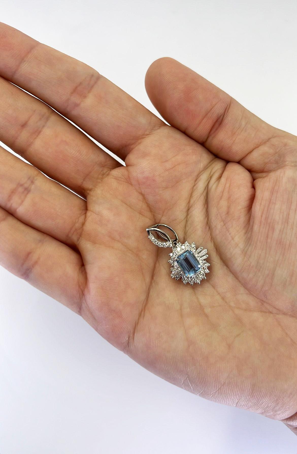 Platinum starburst pendant featuring a 1.21 carat emerald cut aquamarine surrounded by 0.35 carat total weight round and baguette cut diamonds of VS clarity and G/H color. 1 inch long with flexible bale. Finished weight is 5.0 grams.