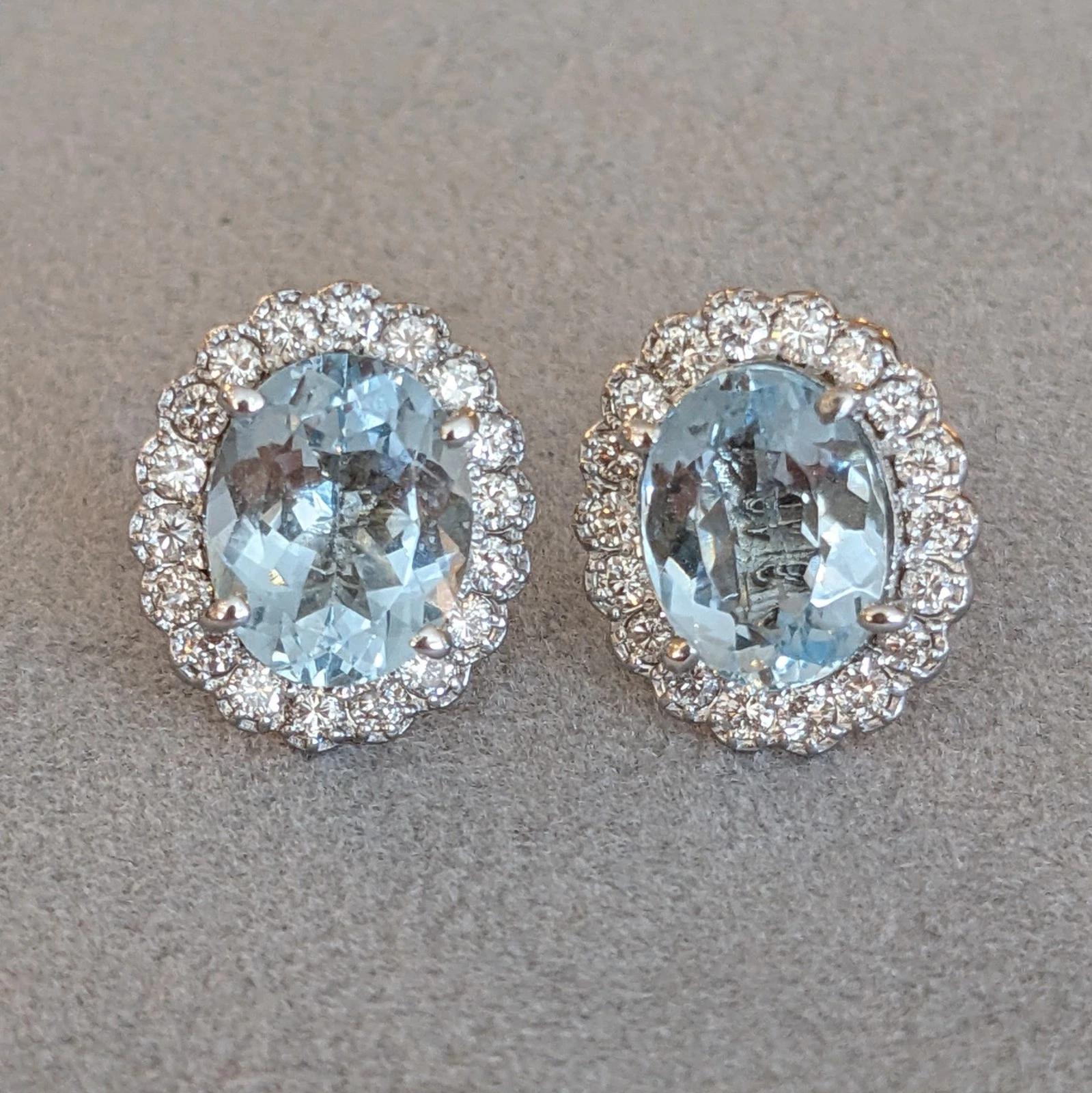 Aquamarine and Diamond Oval Halo Earrings in 18k White Gold 

Aquamarine and Diamond Earrings feature two Natural Oval faceted Aquamarines, weighing 1.97 ct and 2.40 ct, surrounded by a halo Natural Round Brilliant Diamonds, all set in 18k White