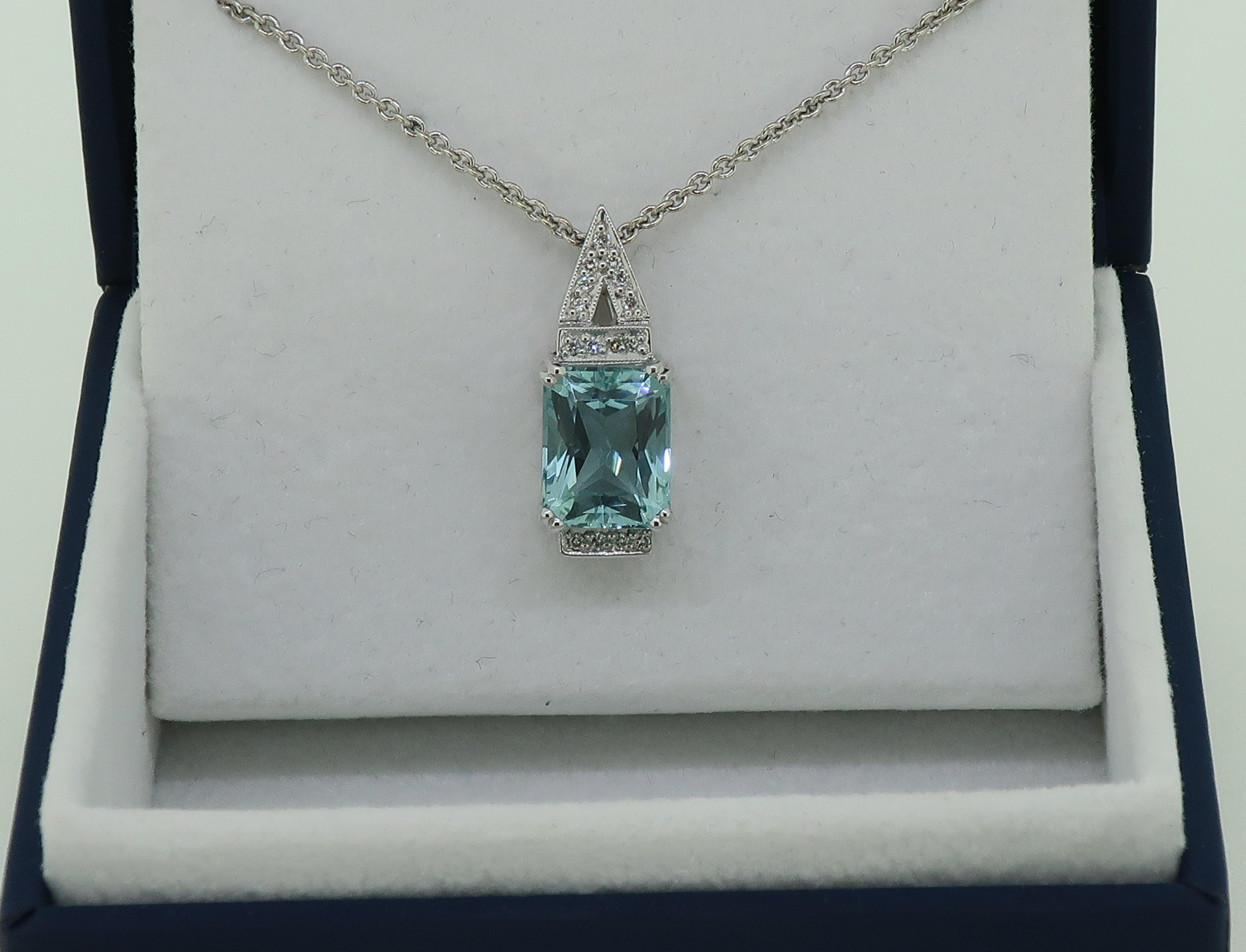 Aquamarine and Diamond Pendant 18 Karat White Gold

Vibrant aquamarine and diamond pendant. Bright blue radiant cut aquamarine measuring 10mm x 7.8mm, set in four double claws. The aquamarine is set off with a row of small round brilliant cut