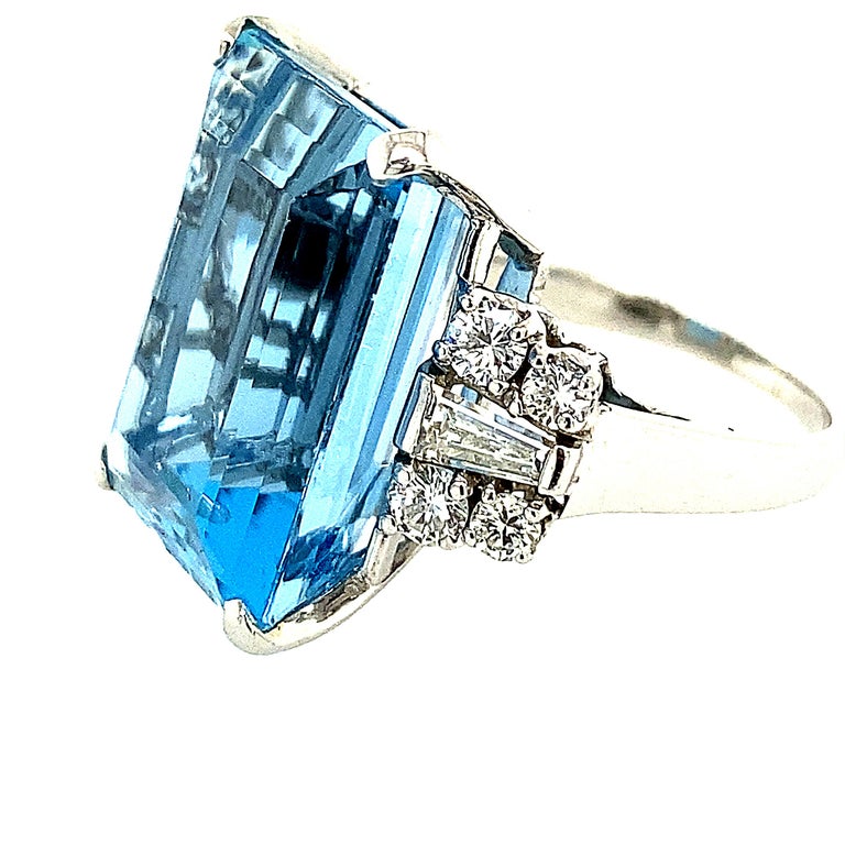 Aquamarine and Diamond Ring. The aquamarine measures 18.00x14.00.9.94mm and weighs approximately 18.40cts. There are 8 round brilliant cut diamonds and 2 taper baguettes. The color is F-G and clarity is VS. The total diamond weight is 1.25cts