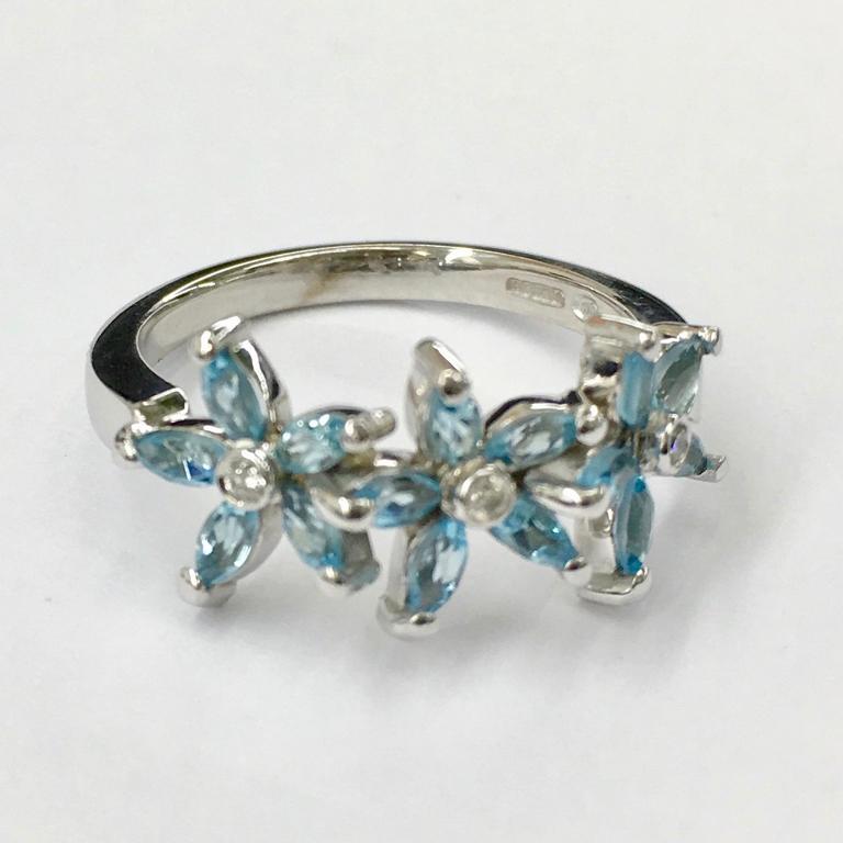 Pretty 18 carat white gold ring with three aquamarine marquise flowers and diamond centre detail. Please note this item is made to order and a similar but not identical piece can be made. Allow four weeks to delivery. 

Esther Eyre has been