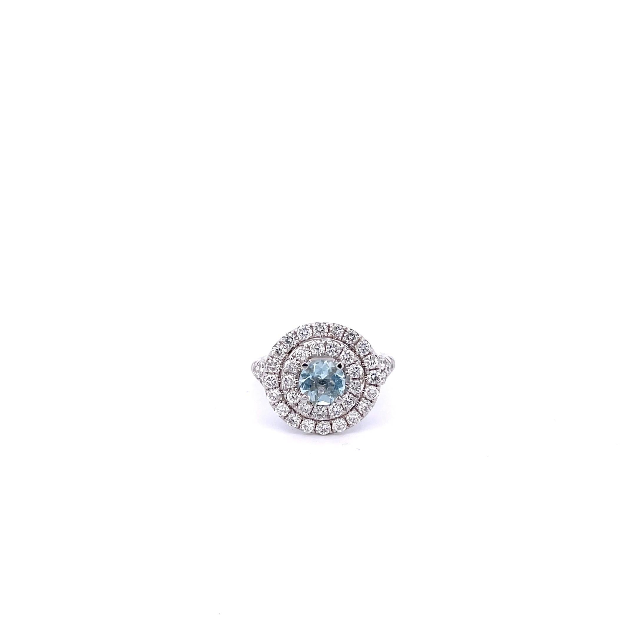 Aquamarine and Diamond Ring in 14K White Gold. The ring features a 6mm round Aquamarine accented by a halo of 1ctw brilliant round diamonds. The ring is size 6. 
