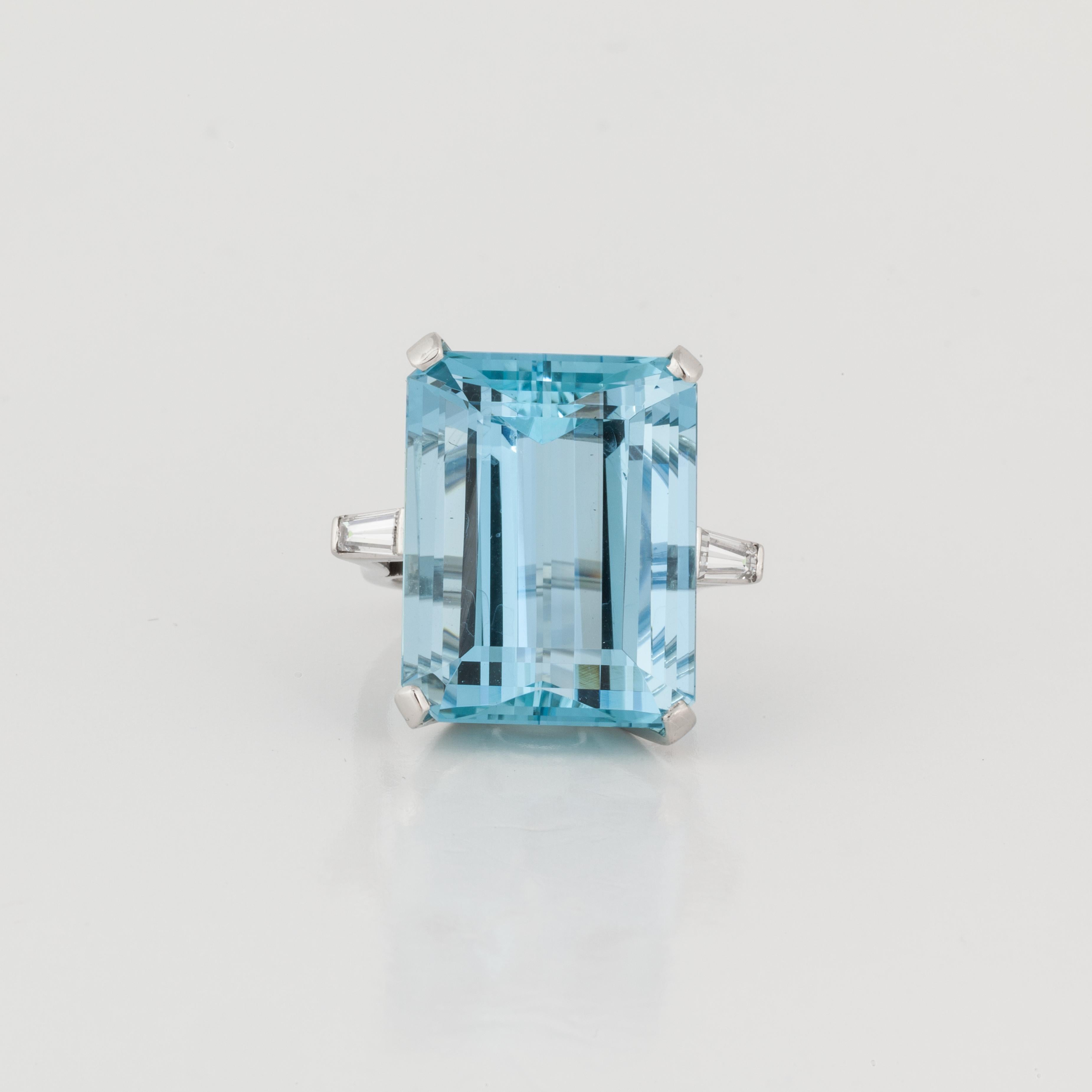 Platinum ring featuring a rectangular-cut aquamarine accented by diamonds.  The aquamarine totals 35.80 carats, with two tapered baguette diamonds totaling 0.60 carats; H-I color and VS clarity.  The ring is currently a size 7 1/4, and may be sized.