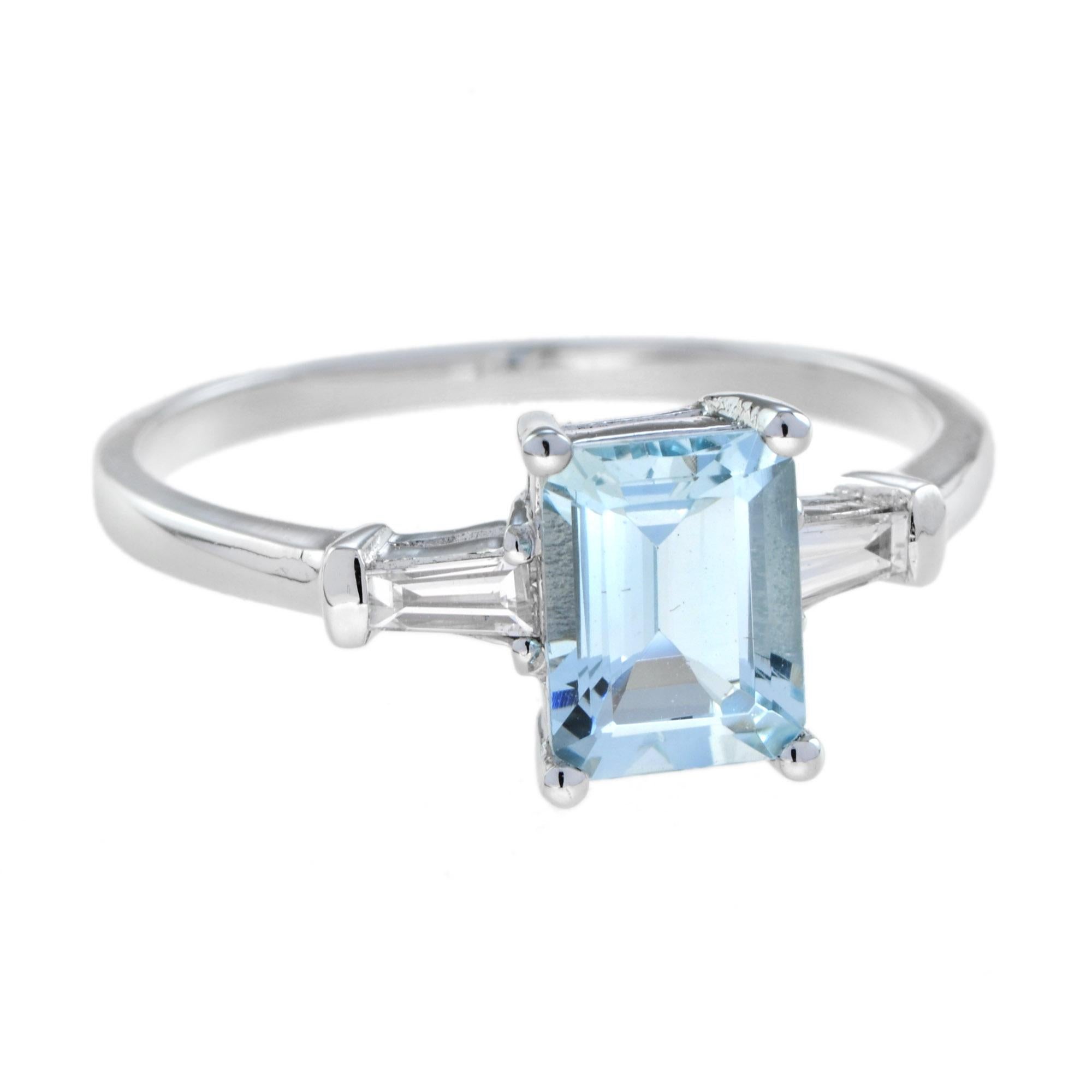 This beautiful ring has a single 8x6 mm. natural aquamarine with traditional emerald cut, prong-set in an elegant mount with daylight shoulders. Featuring a baguette diamond on each shoulder in solid 18K white gold. 

Ring Information
Style: Art