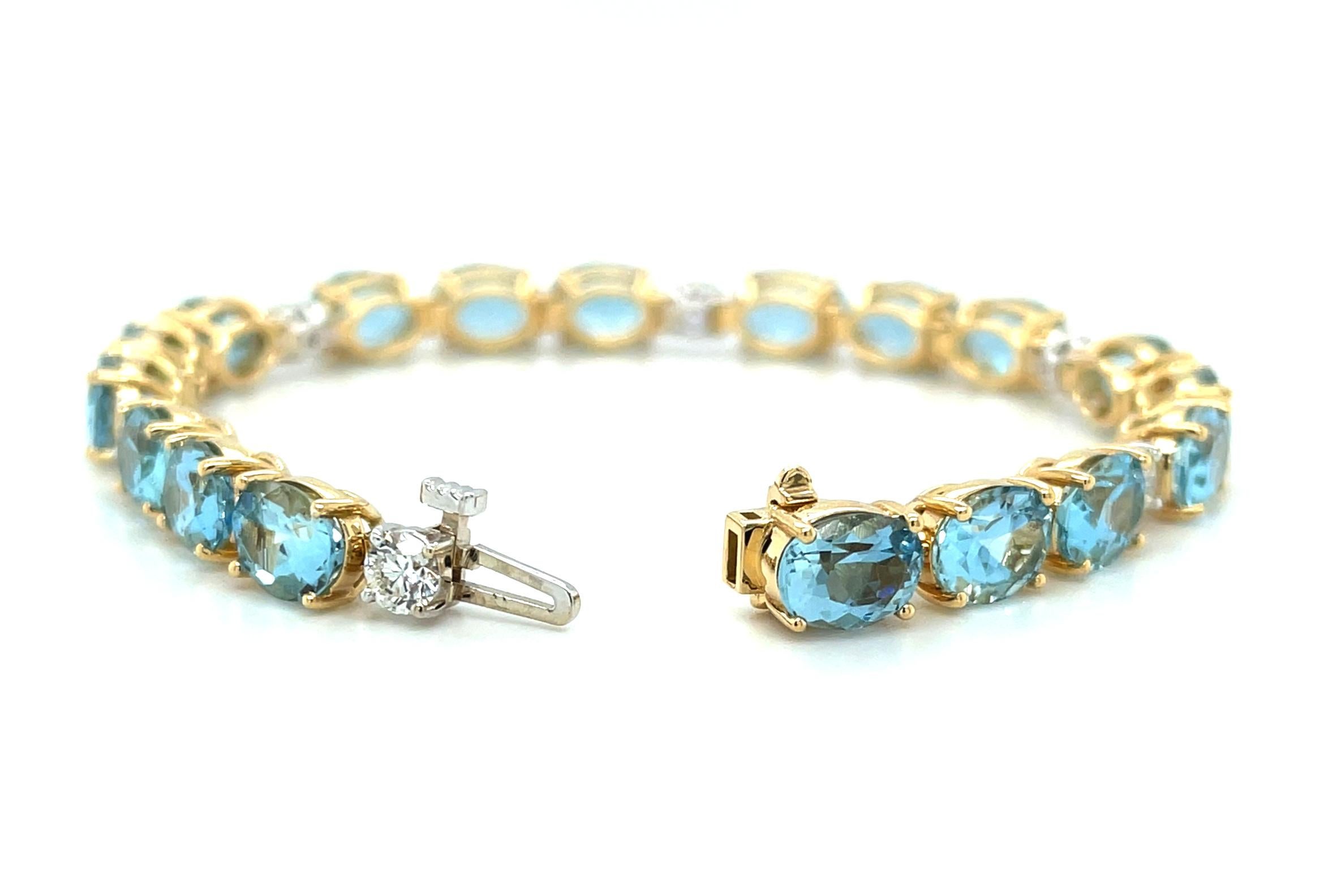 This sparkling aquamarine and diamond tennis bracelet is absolutely stunning! It is set with 18 beautifully matched, oval aquamarines with eye-catching brilliance and bright medium blue color. Each crystalline gemstone weighs over a carat, large