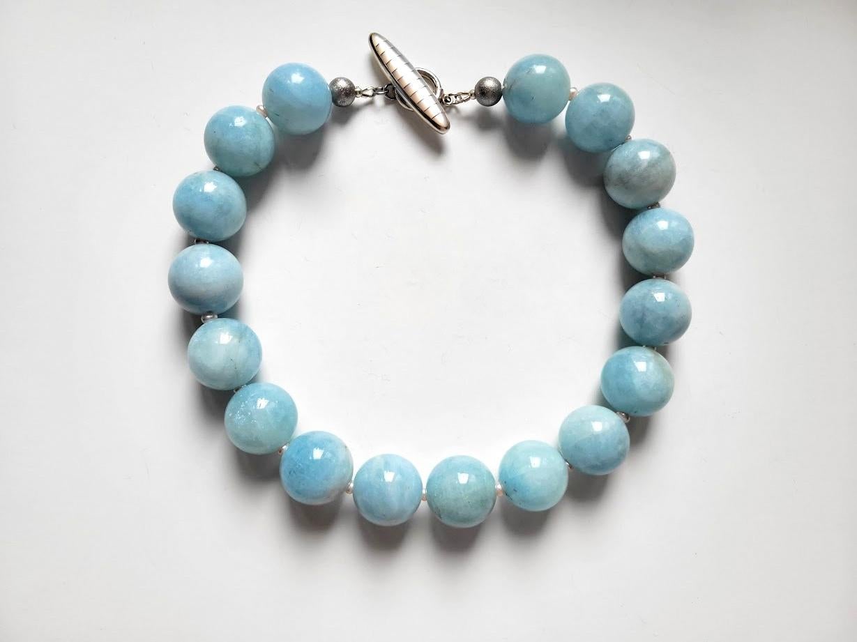 The necklace is 18.5 inches (47 cm) long. The rare size of the huge smooth round beads is 23-24 mm. 
The beads are a soft shade of blue sky—a very gentle, soft pastel color! These are beautiful statement beads of Blue Aquamarine!
Aquamarine is a