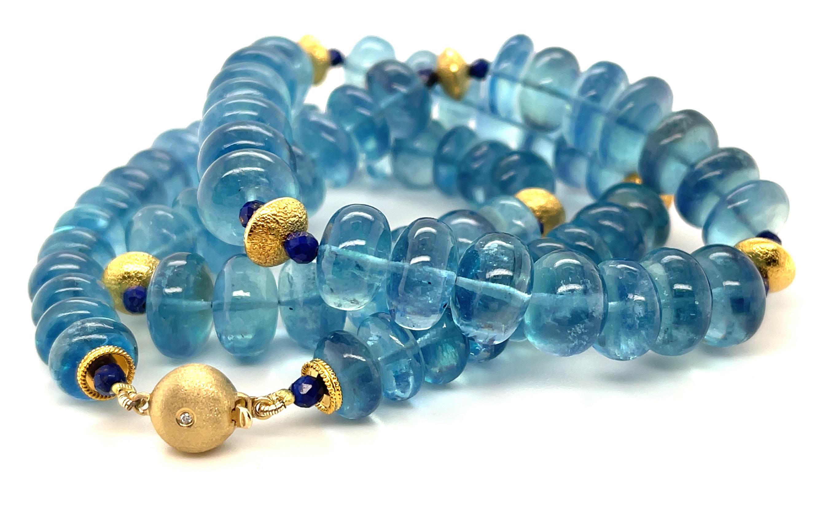 This gorgeous gemstone necklace features a beautiful collection of stunning Santa Maria blue aquamarine beads that have been paired with lapis lazuli beads and accented with rich 18k yellow gold. The aquamarine rondels graduate in size from 9mm to