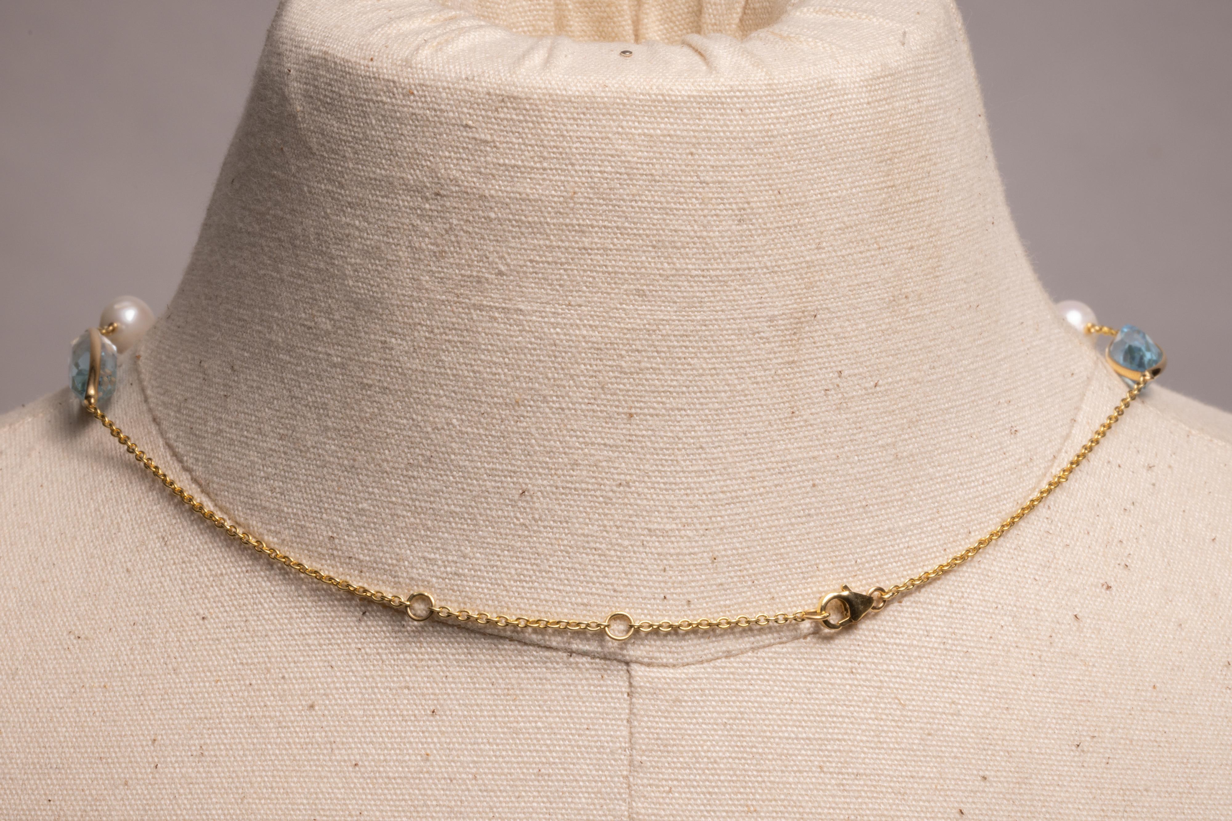 Un superbe collier composé de cinq aigues-marines marquises à facettes bordées d'or, entrecoupées de perles d'eau douce et d'une chaîne en or 18 carats.  Des anneaux optionnels dans le dos permettent d'ajuster la longueur entre 16 et 18 pouces.  Le