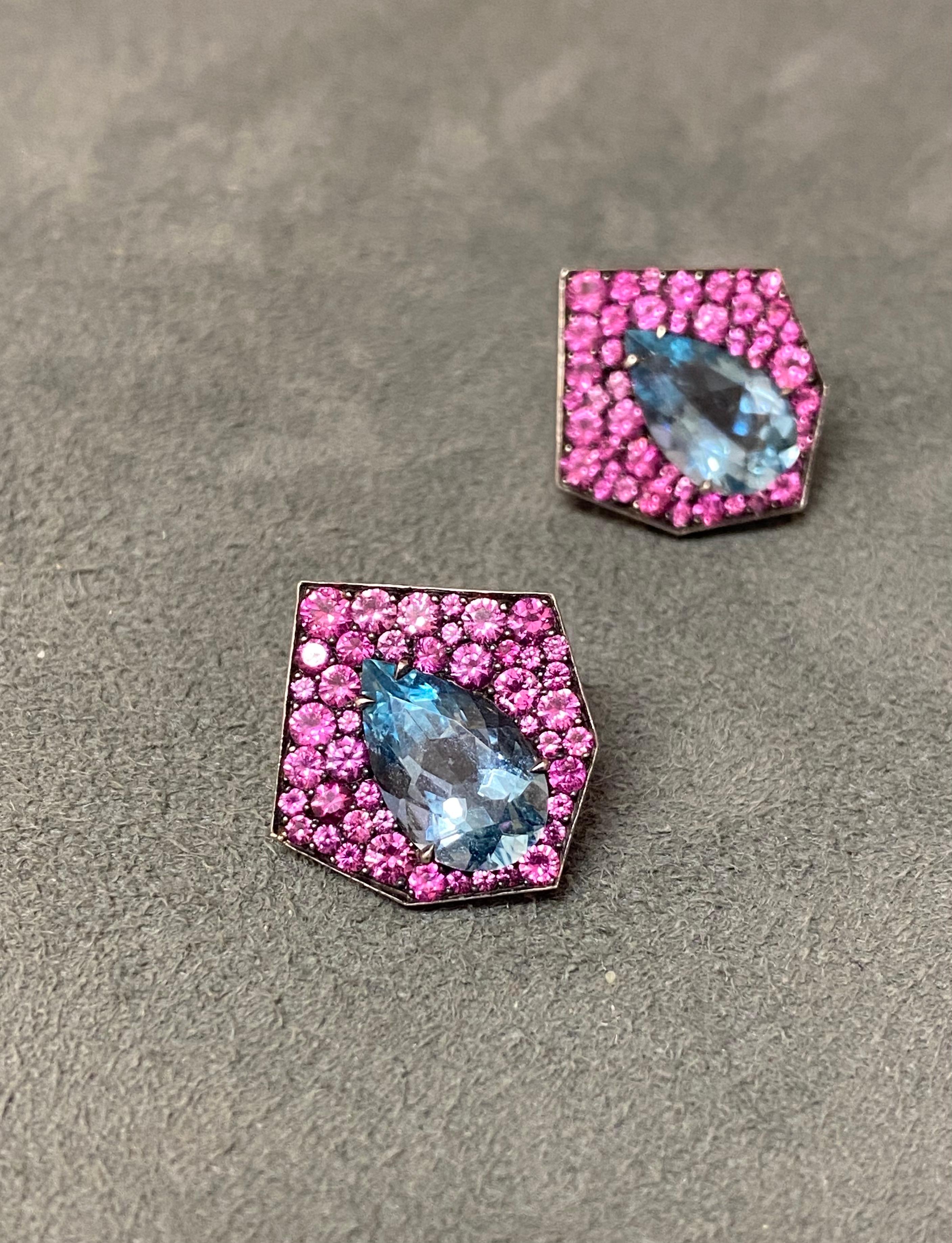 Two pear shaped aquamarines set with pink sapphires in 18k rose gold and blackened silver. The two aquamarines have a combined weight of 4.09ct, and the sapphires have a combined weight of 2.47ct. The earrings come with alpha system stud backings.