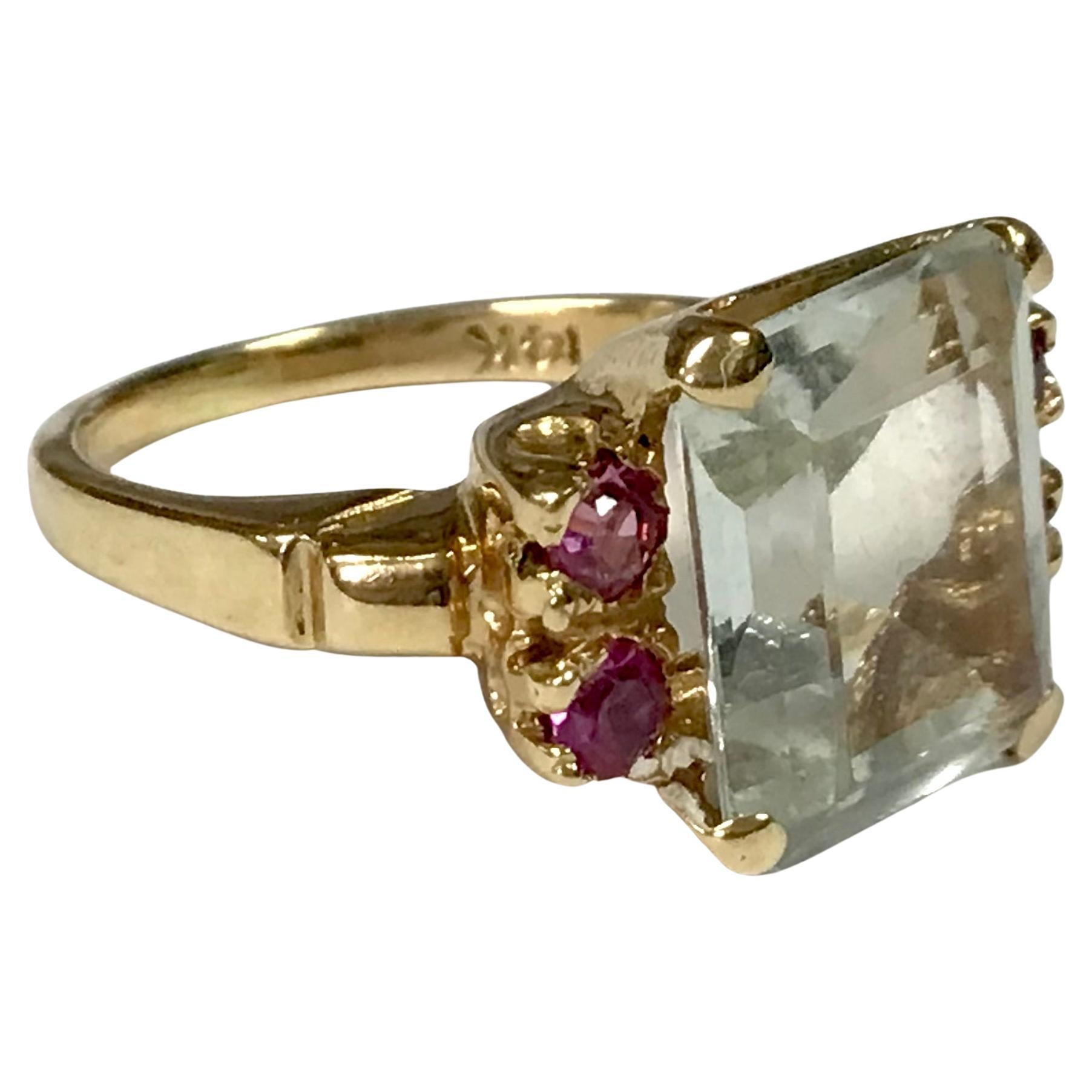 Anello in oro giallo 14K, acquamarina e rubino, misura 6. Acquamarina taglio smeraldo centrata da quattro rubini rosa rotondi abbinati. Acquamarina di circa 5 carati. 