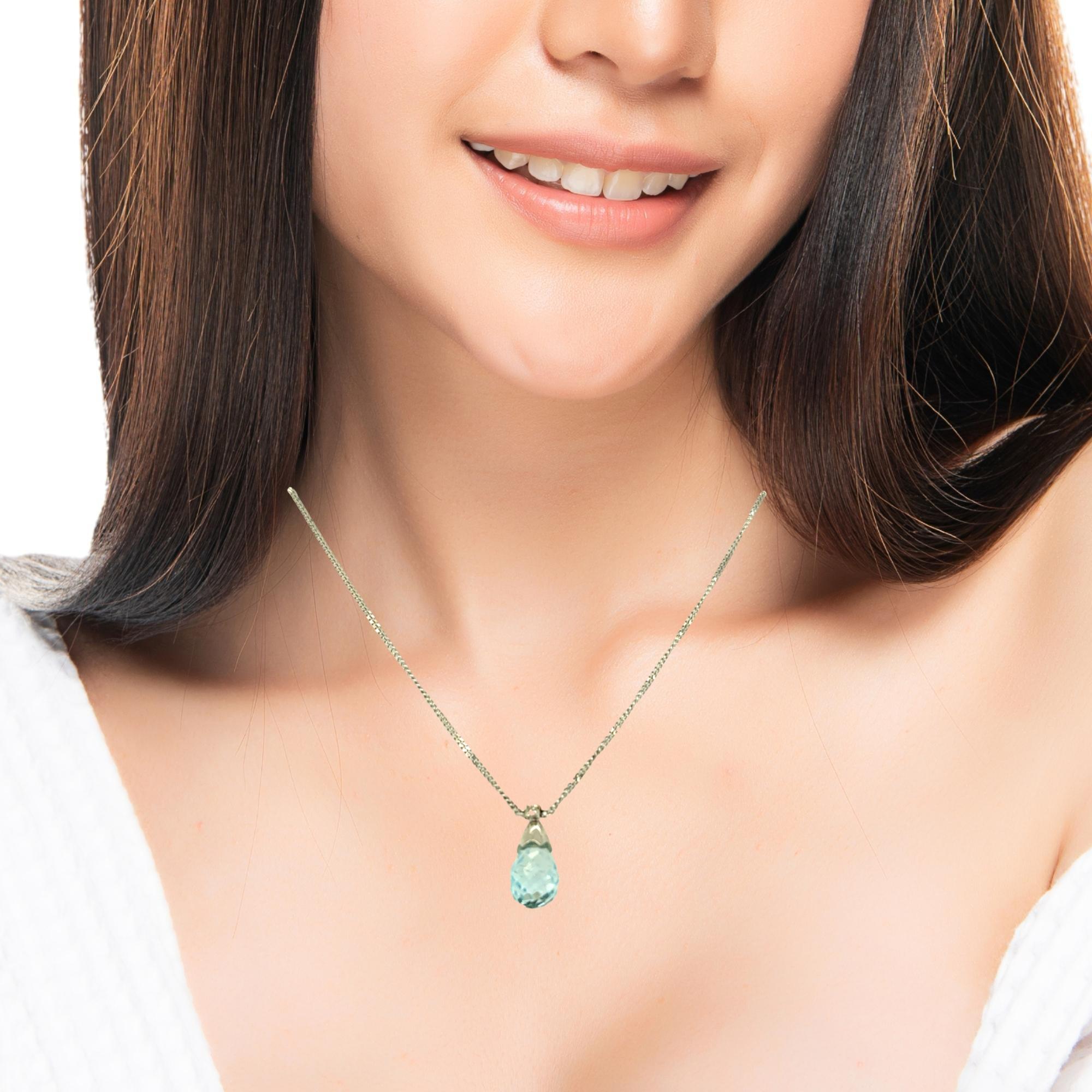 L'eleganza del blu tenue incontra lo scintillio senza tempo.
Questa delicata collana presenta una briolette di acquamarina sfaccettata (larga circa 7,8 mm) che cattura la luce a ogni movimento. Sormontato da un diamante rotondo brillante, il