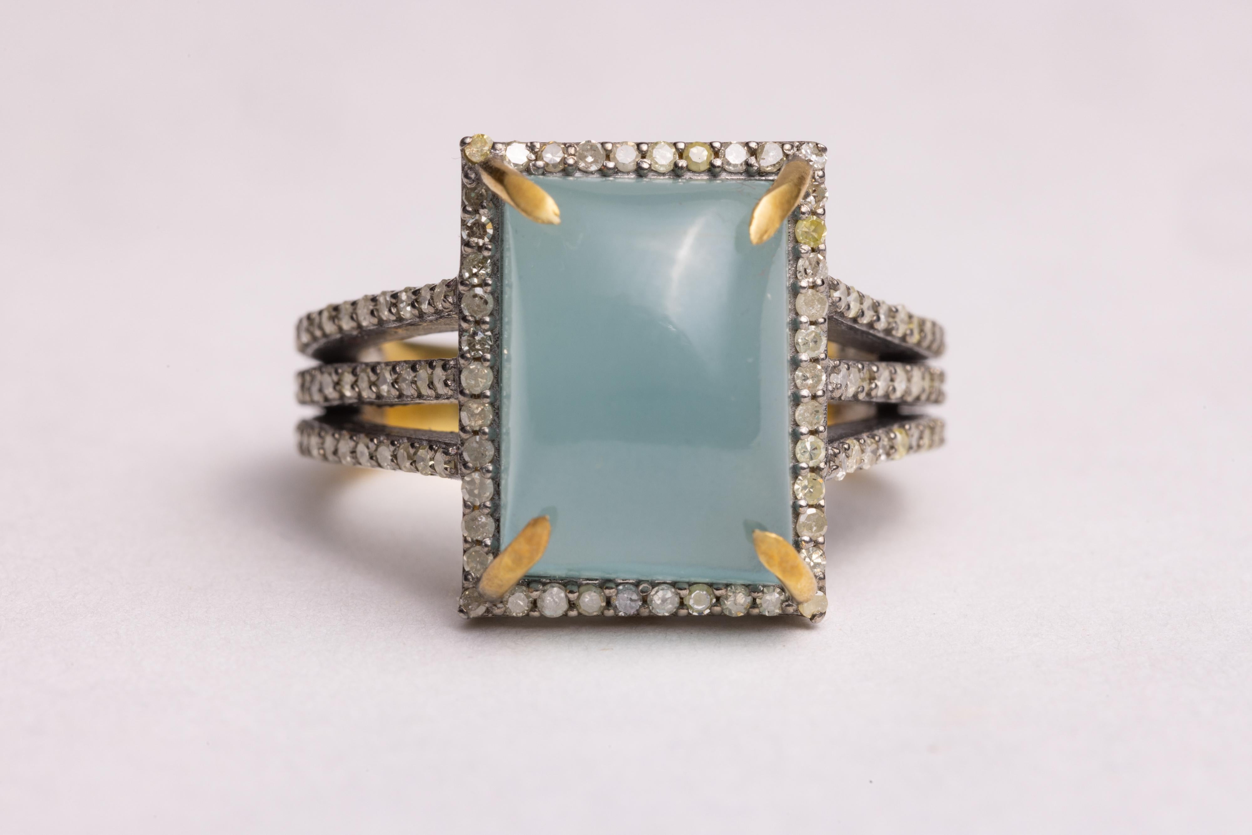 A lovely large, rectangular cabochon aquamarine with a border of round, brilliant cut diamonds in a pave` setting.  Set in sterling silver.  Carat weight of diamonds totals .68.  The aquamarine is 7.33 carats.

he fine jewelry collection is sourced,