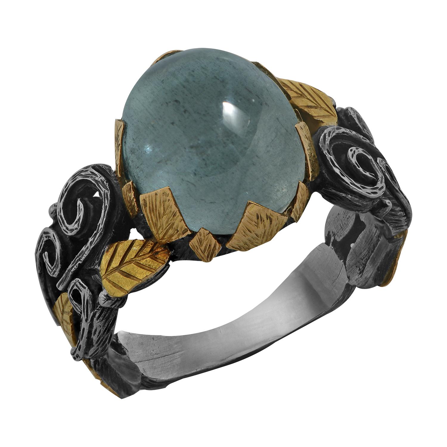 

This gorgeous one-of-a-kind aquamarine ring has been handmade in our workshops. It features a central cabochon aquamarine, set in 18k gold hand-engraved motifs. The shank is a mixture of oxidized sterling silver and 18k gold which also has