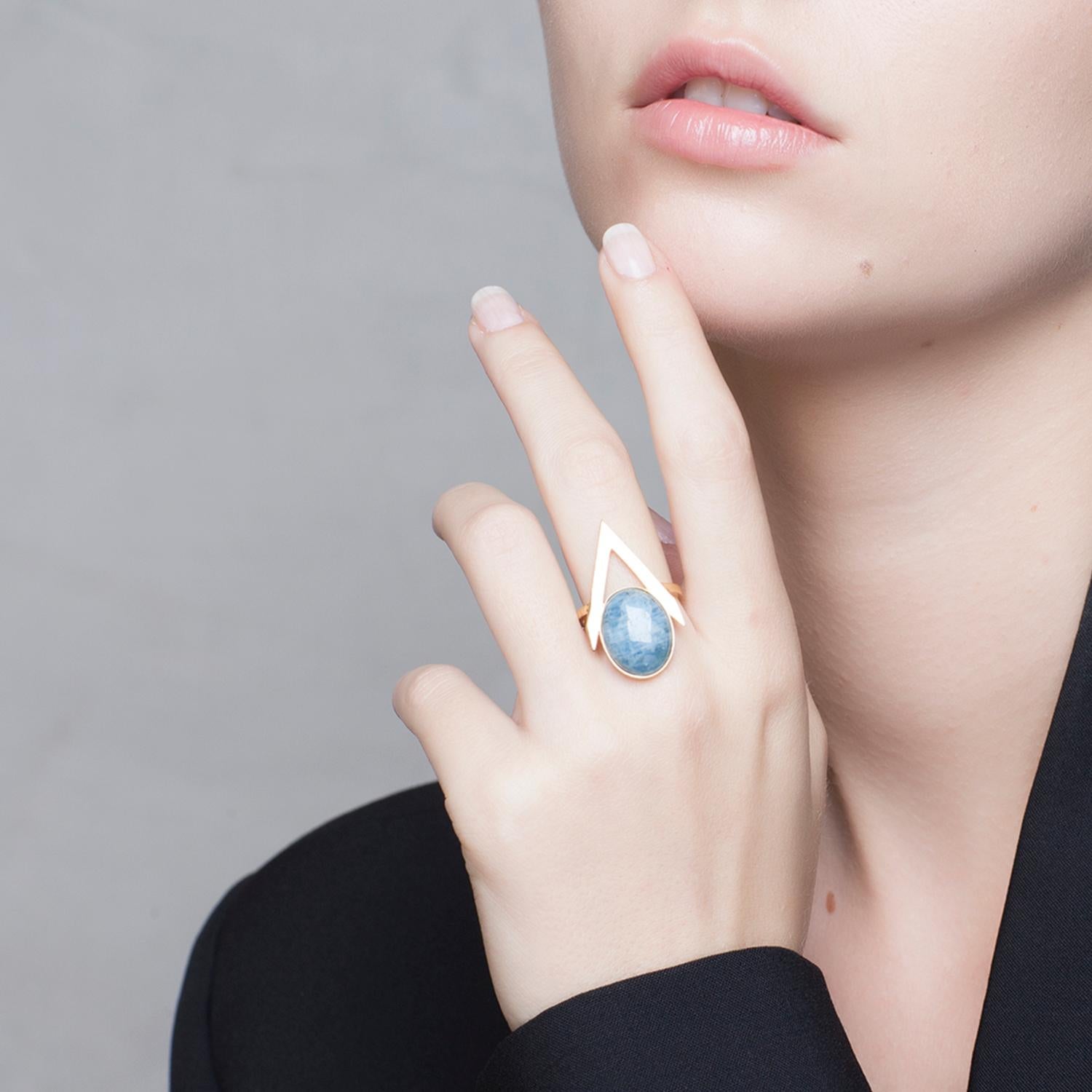 Add jewellery with a modern, feminine attitude to your outfit with this graphic ring from Iosselliani.  Crafted in Italy in 9 Karat gold, the ring features a medium sized pink opal cabochon framed into a V shape. Stone size 16 x 12 mm. Central
