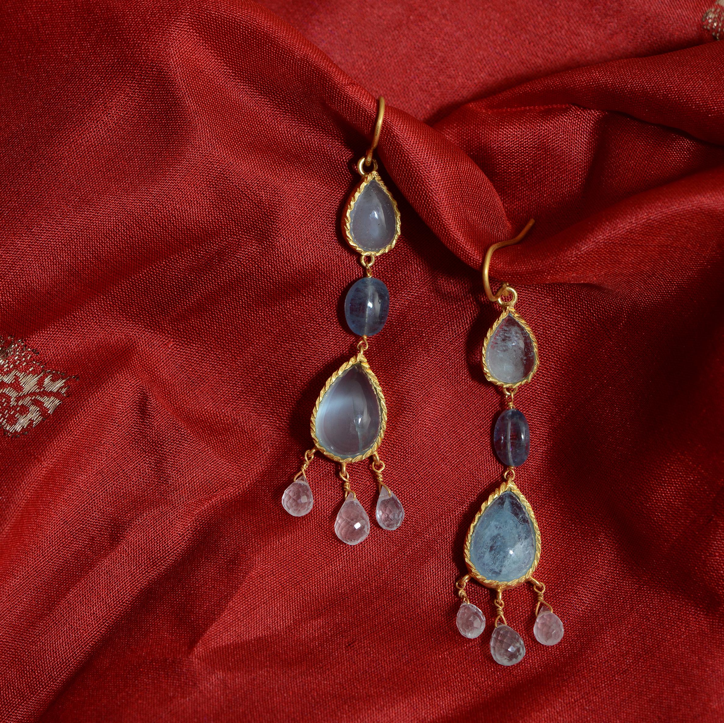 These stunning aquamarine cabochon teardrop earrings are from a limited edition. They have been handmade in our workshops and have a matching pendant and ring. They are made in sterling silver coated with 24k gold plate.

This collection was