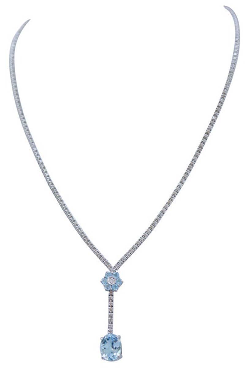 Fantastic tennis necklace in 14 kt white gold structure mounted, for all the lenght, with diamonds. As pendant, a flower of topazs with a central diamond; below of it, diamonds and, in the final part, an oval topaz.
This necklace was totally