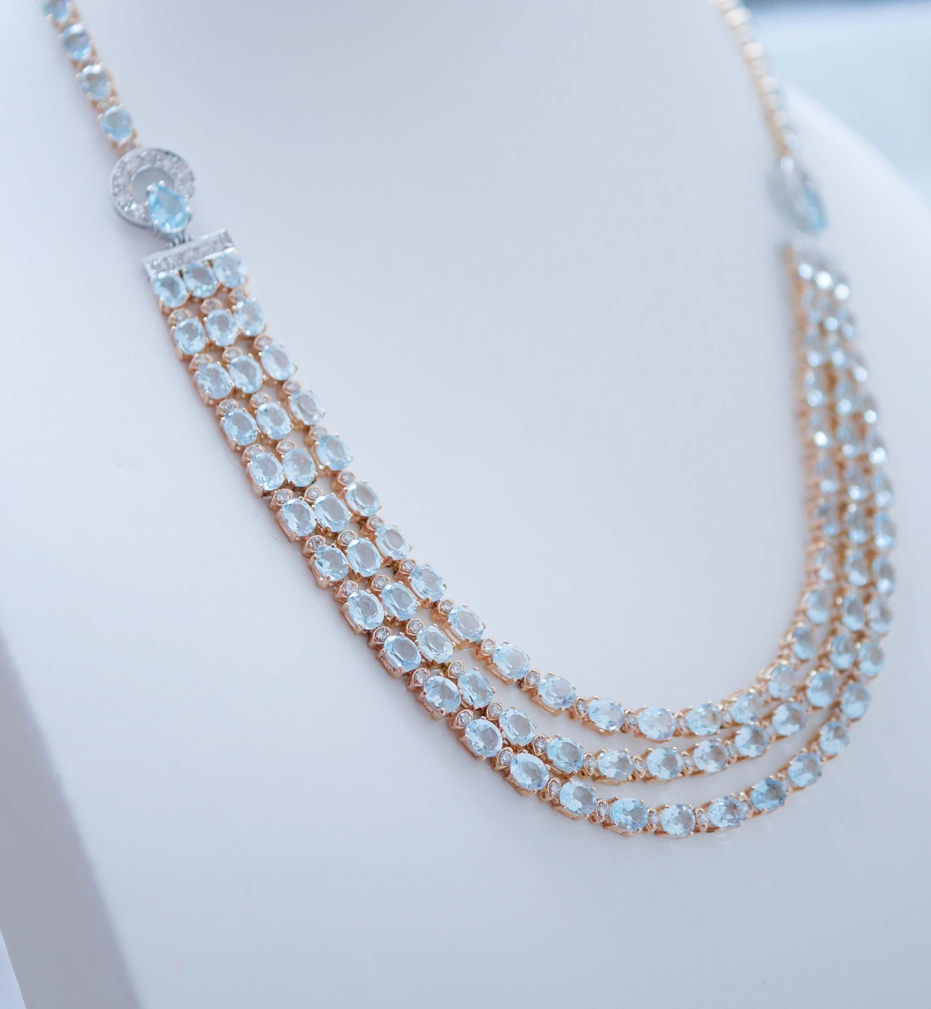 Beautiful necklace in 14 karat white and rose gold mounted with three rows of aquamarine colour topazs in the central part linked to structures in white gold with diamonds and a drop topaz  and a strand of  topazs in the final part. Between the