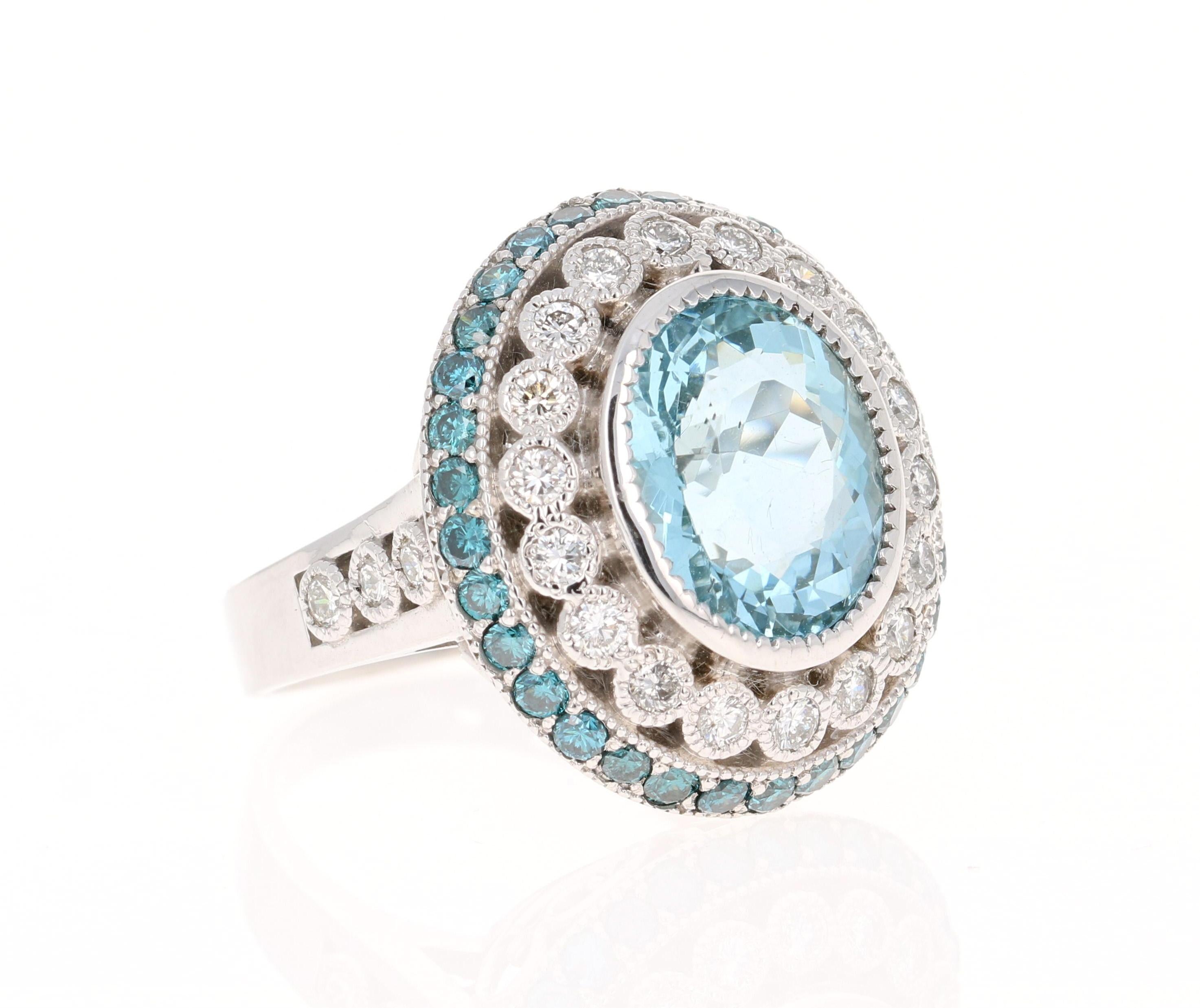 This ring has a beautiful 4.73 Carat Oval Cut Aquamarine and is surrounded by 32 Round Cut Blue Diamonds that weigh 0.96 carats. The Blue Diamonds are color treated to achieve its blue color as per industry standards. There are also 24 Round Cut