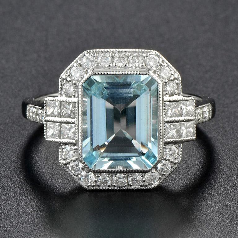 This Art Deco Style Aquamarine Diamond Cocktail Ring was made in 18 Karat White Gold.
The center gorgeous blue emerald-cut aquamarine (size 10 x 8 mm) 2.7 Carat glistens with small bright-white round brilliant-cut Diamonds 0.42 Carat and square