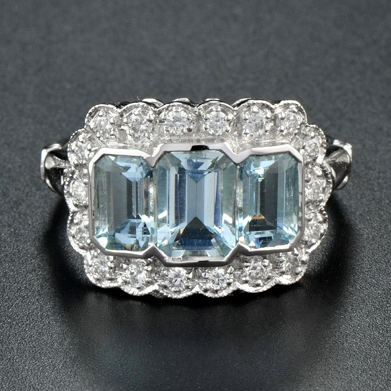 This Art Deco Style Ring was made in 18 Karat White Gold.
The center triple of blue emerald-cut aquamarine (size 7x5 mm. and 6x4 mm.) 2.3 Carats. glistens with small bright-white round diamonds 0.29 Carats. 
Currently size 8. Total weight