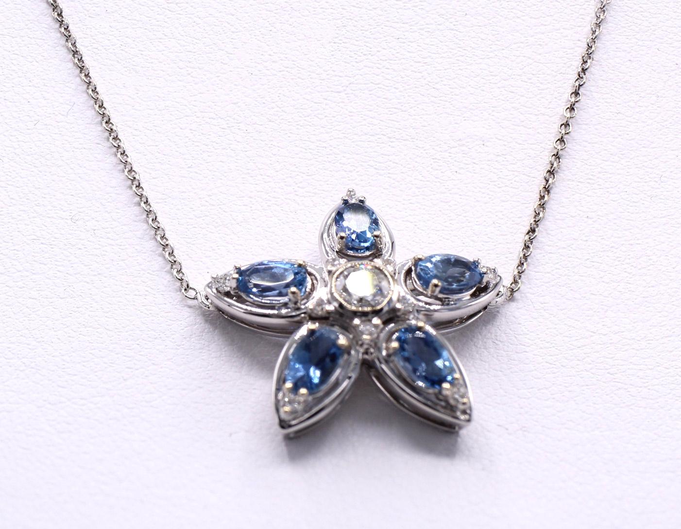 Beautifully designed and masterfully handcrafted this lovely pendant necklace in the shape of a starfish is set with 5 deep saturated lively oval aquamarines with a bright white and sparkly round brilliant cut diamond in its center and small round