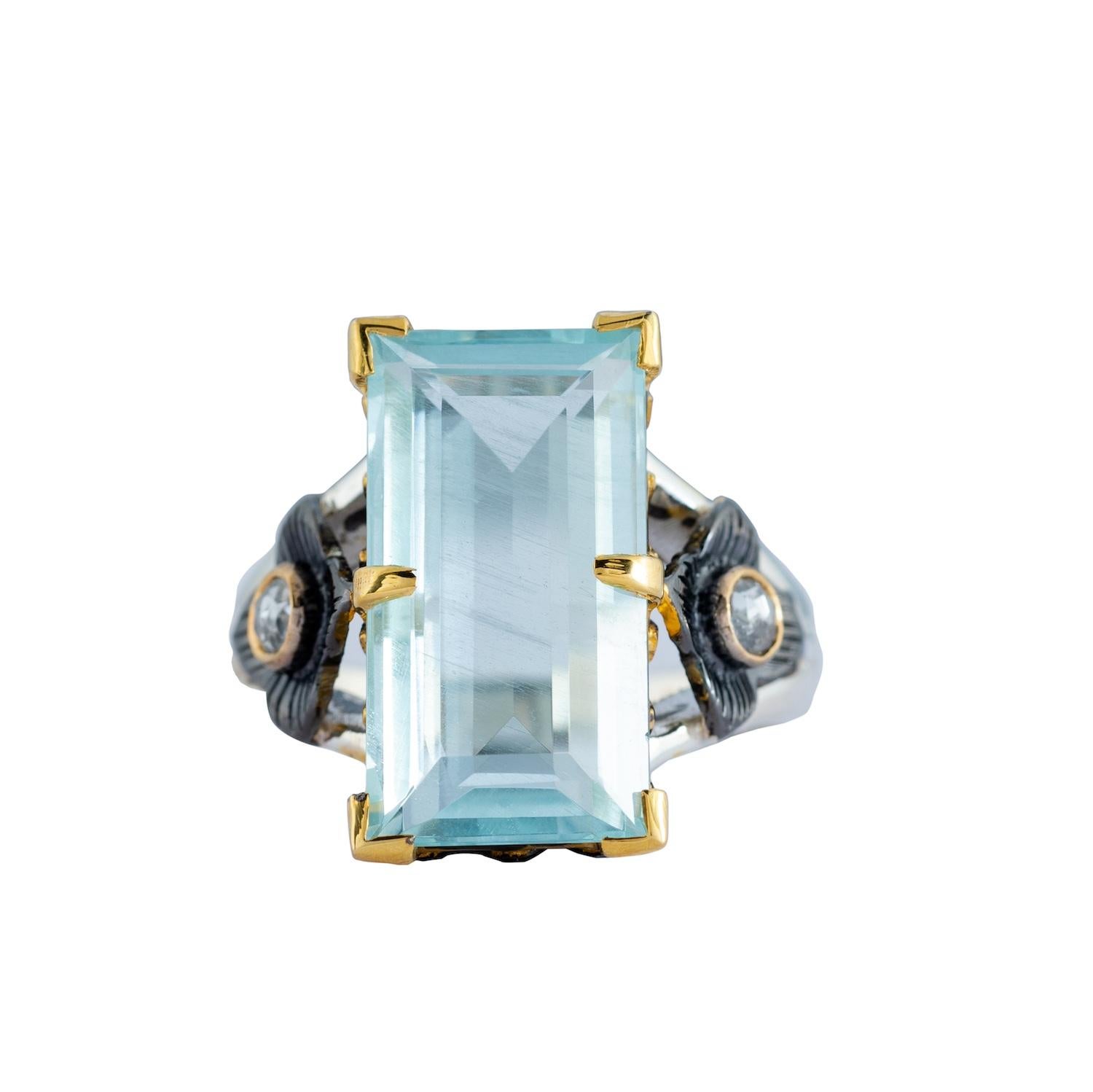 A stunning one-of-a-kind aquamarine cocktail ring which has been handmade in our workshops. This statement ring, features an 8.27ct aquamarine which is flanked by two rose cut diamonds all set in 14ct gold. The shank is made of oxidized sterling